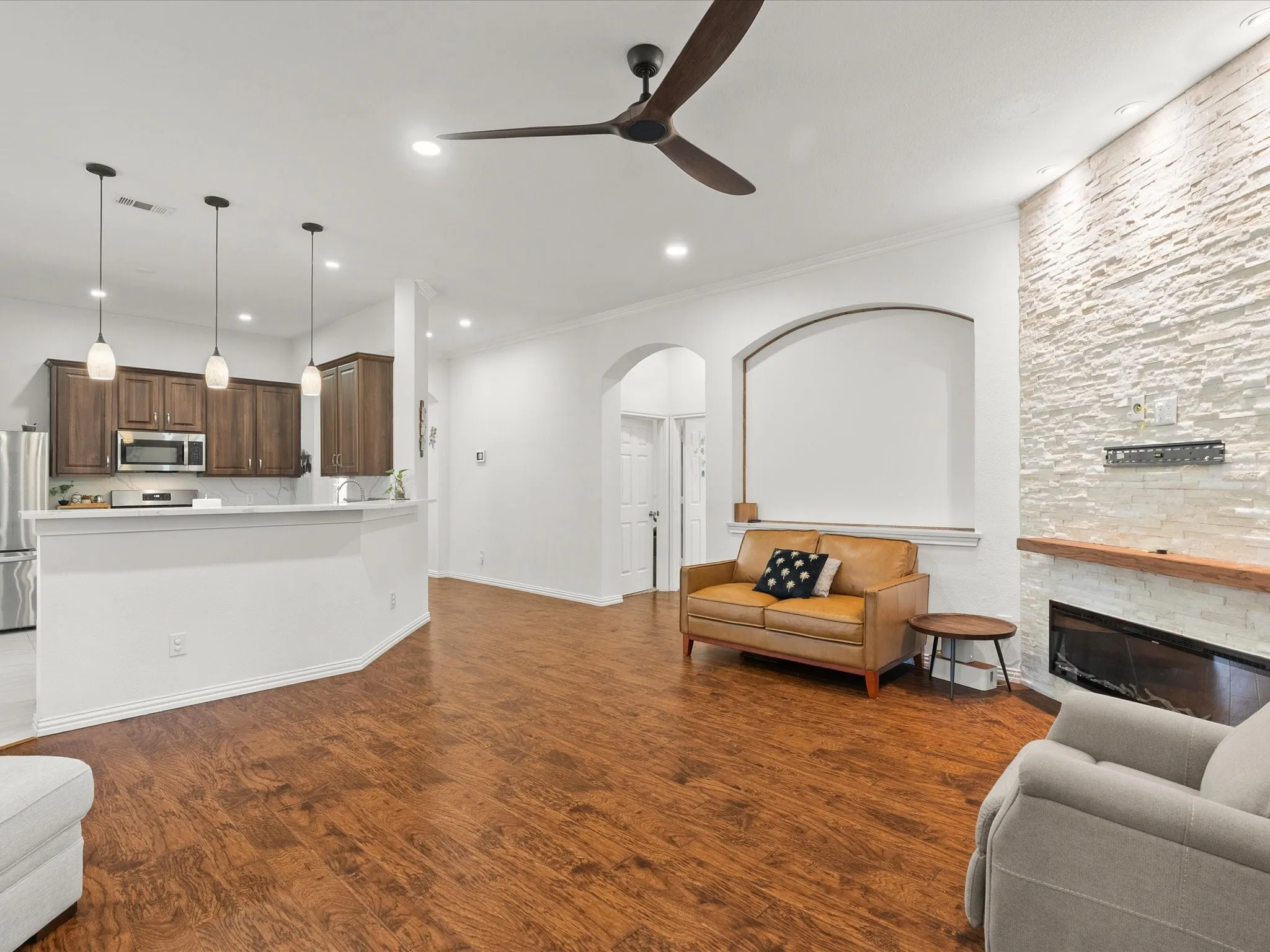 Wood-finish flooring throughout, complemented by recessed lighting and a ceiling fan