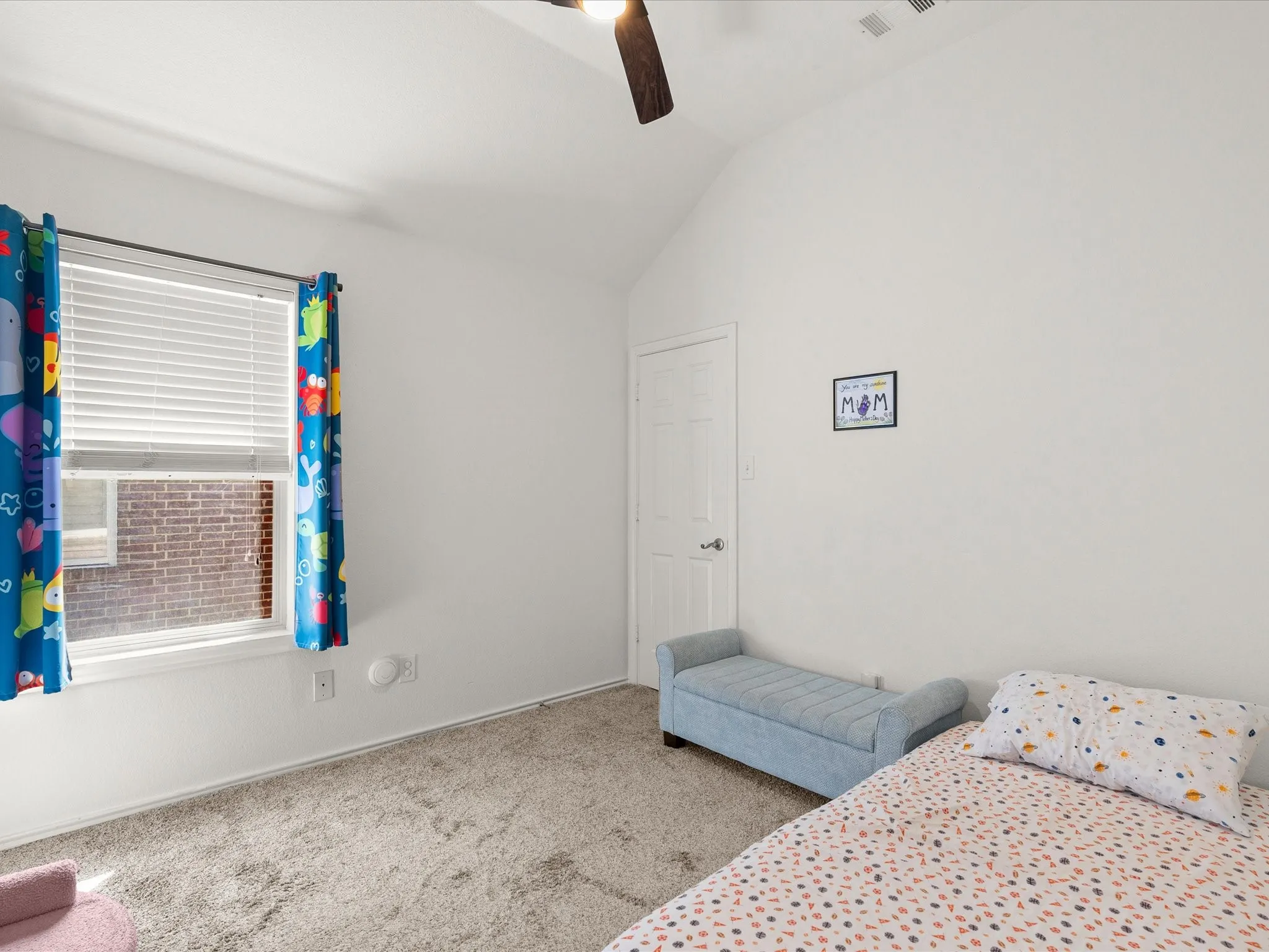 Vaulted ceiling, white walls, carpeted flooring, window with blinds, and a paneled door