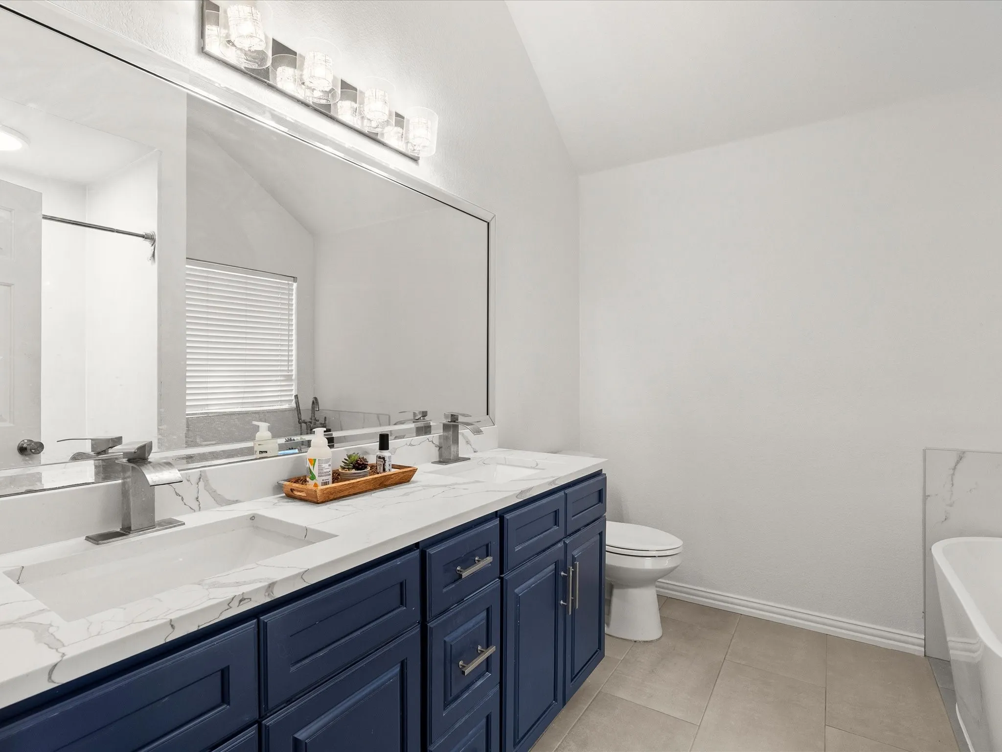 Dual vanity with quartz countertops, undermount sinks, and polished chrome faucets