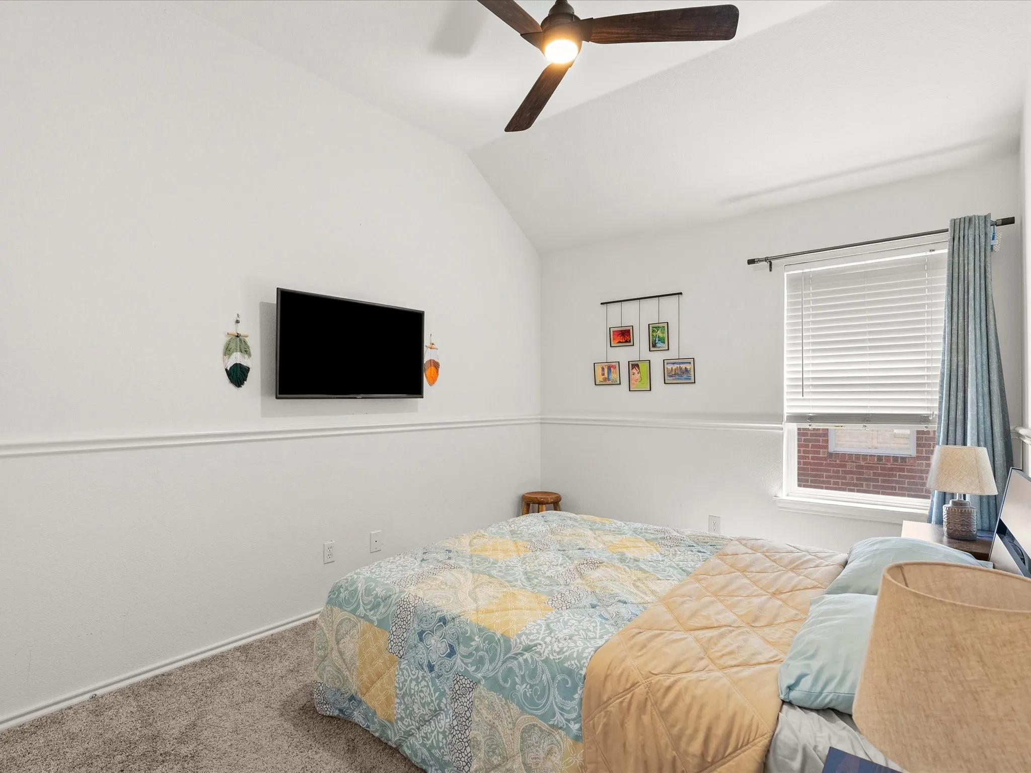 Vaulted ceiling, carpeted flooring, window with blinds, decorative wall molding, and a ceiling fan