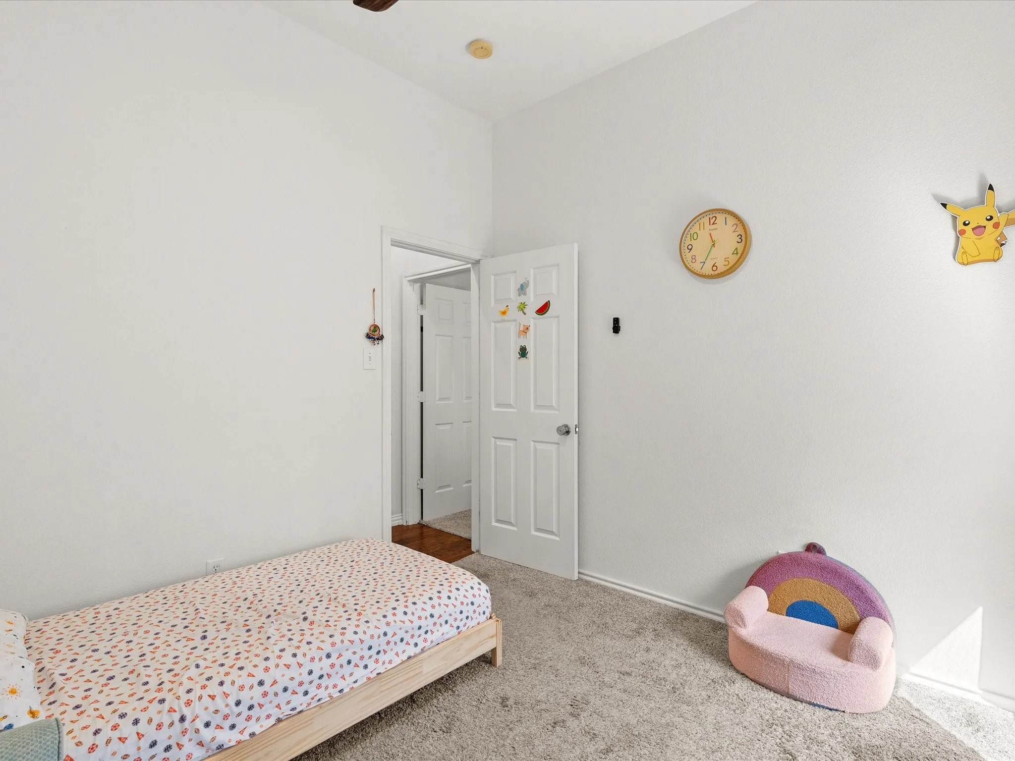 Carpeted flooring, white walls, and a white interior door with a silver-tone knob