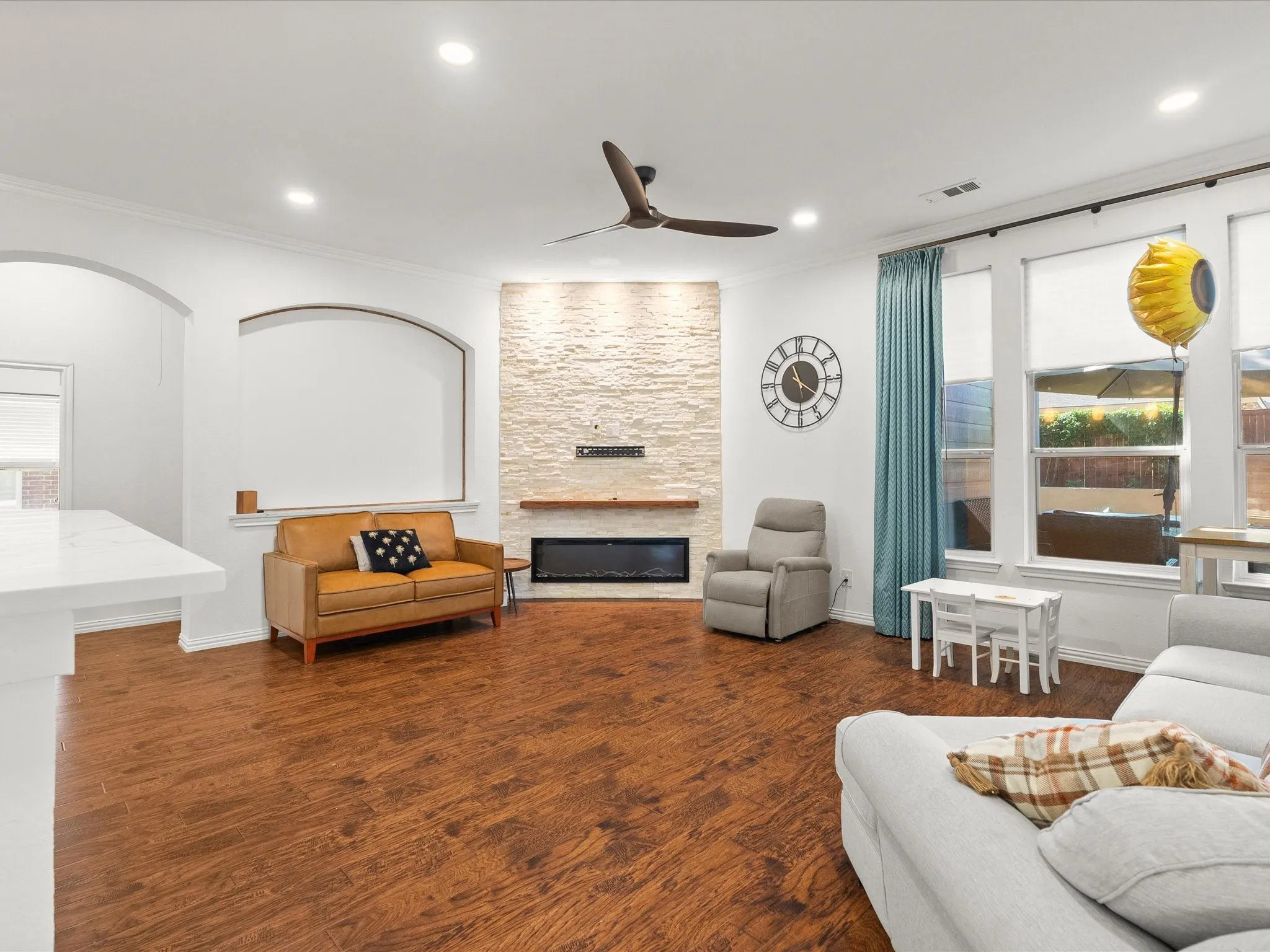 Open-concept living area featuring wood-finish flooring, recessed lighting, and a modern ceiling fan