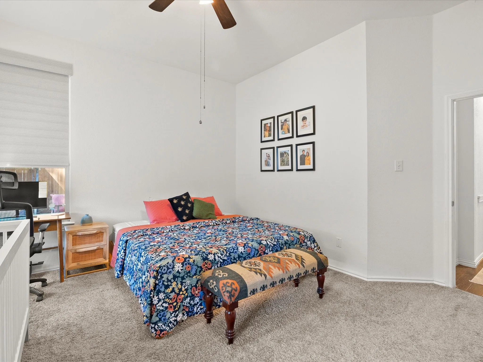 Vaulted ceiling with a ceiling fan, window with roller shades, and plush carpeting
