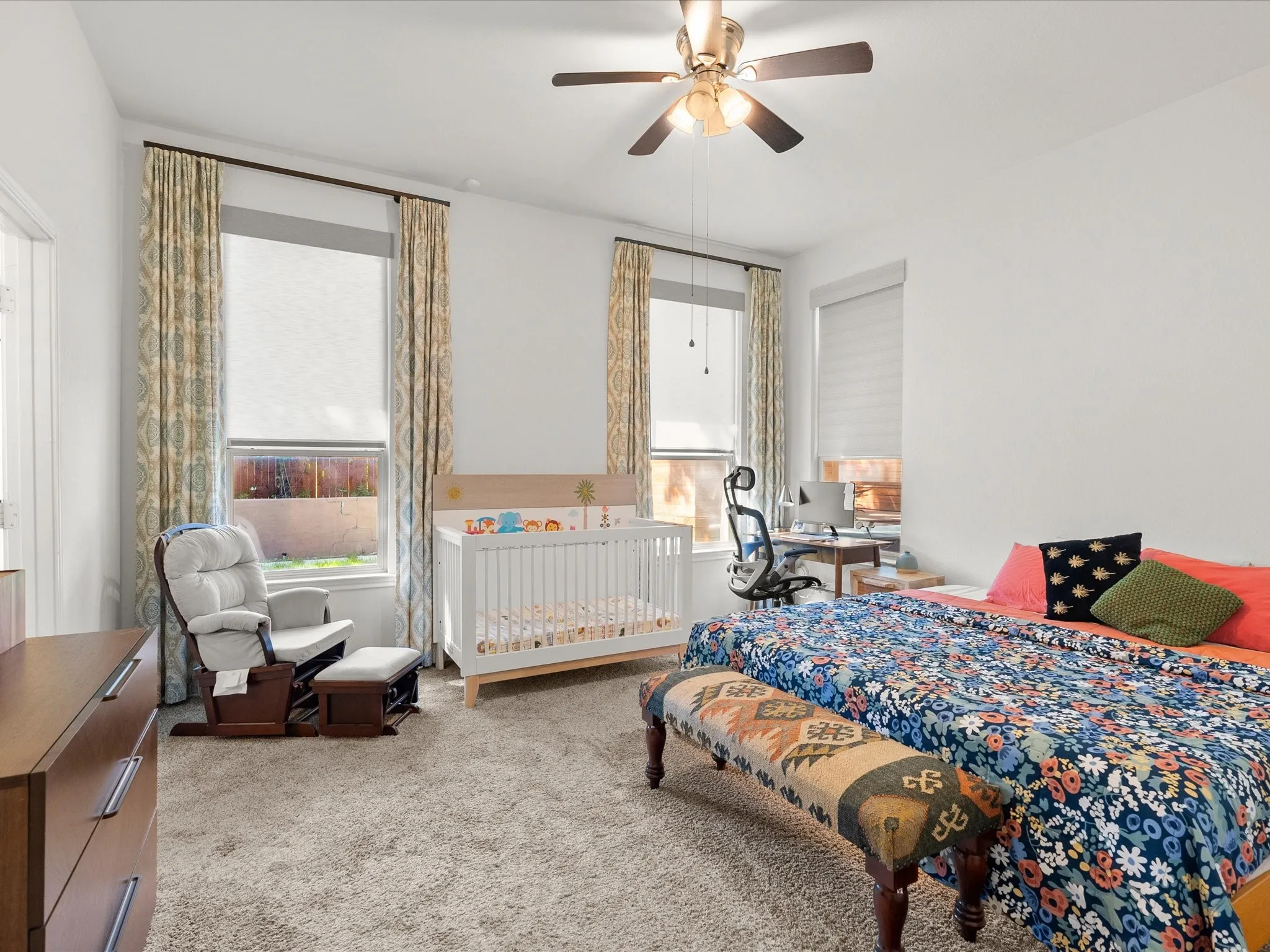 Carpet flooring, ceiling fan with integrated lighting, and multiple windows providing natural light