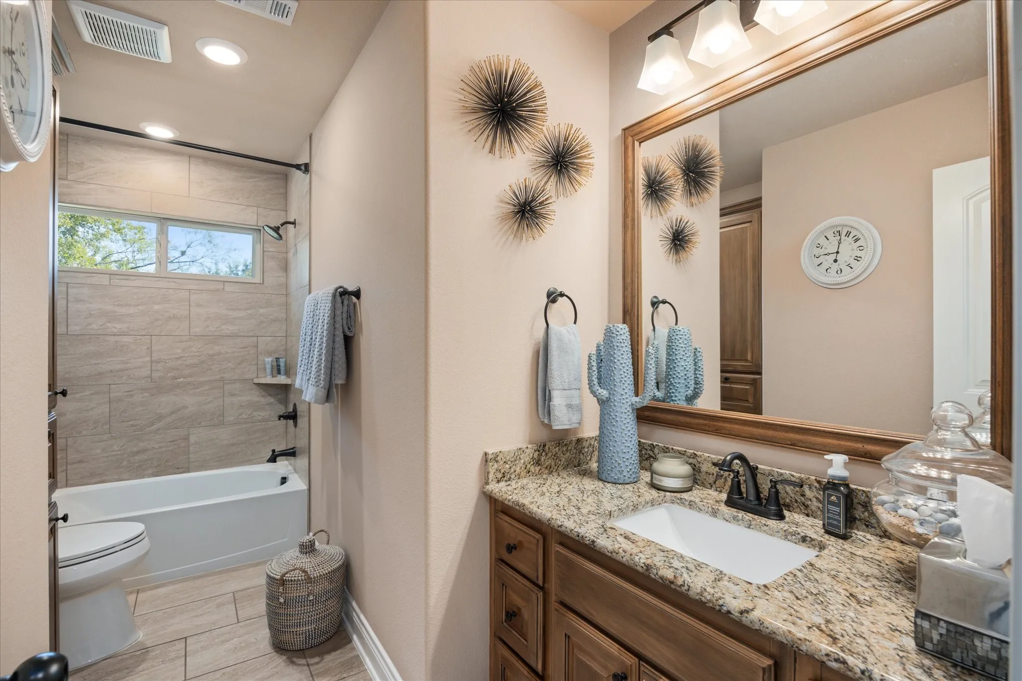 Bathroom vanity with granite countertop, integrated sink, and wood-finish cabinetry