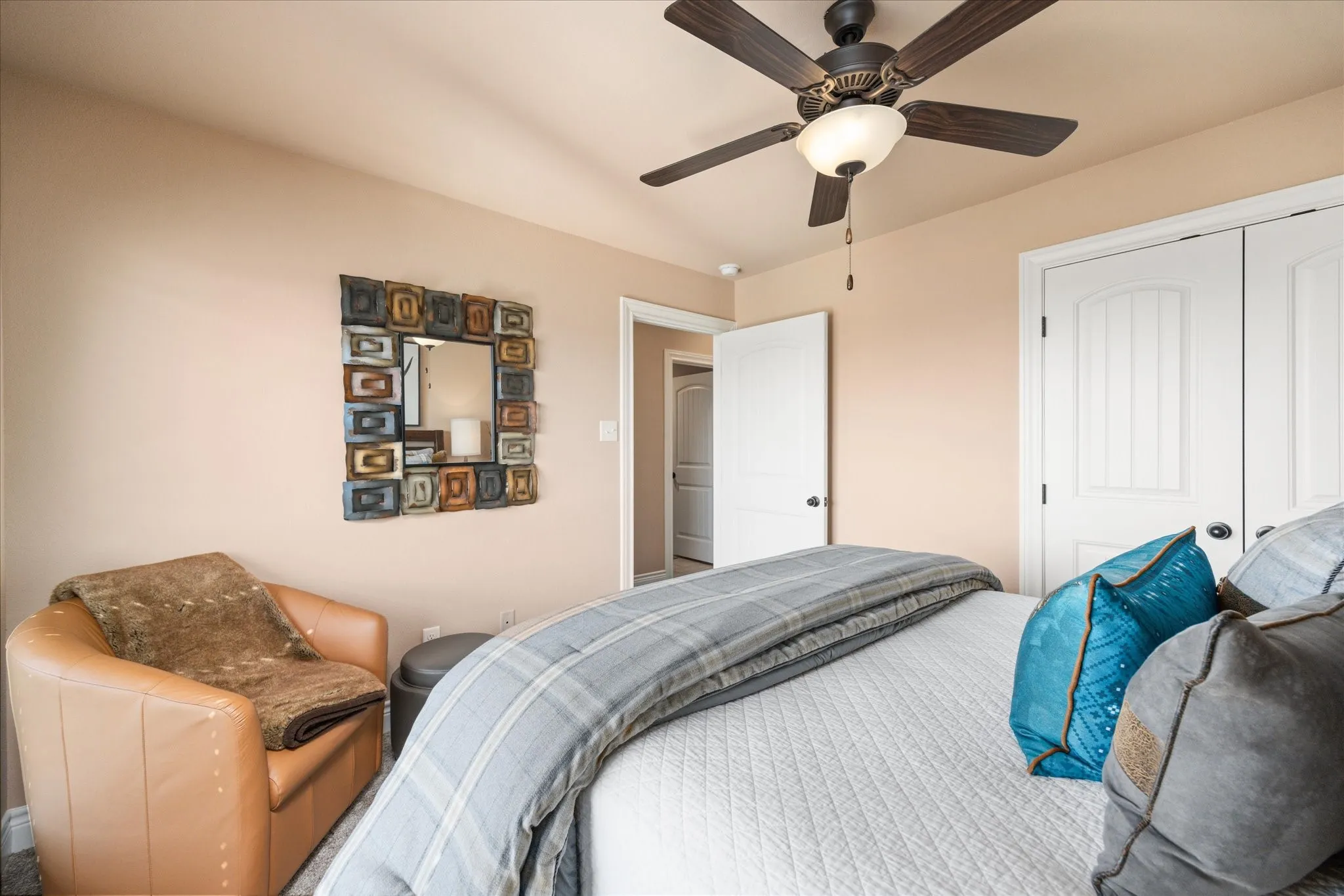 Ceiling fan with integrated lighting, solid core interior doors, neutral wall tones, decorative wall mirror, and plush carpet flooring