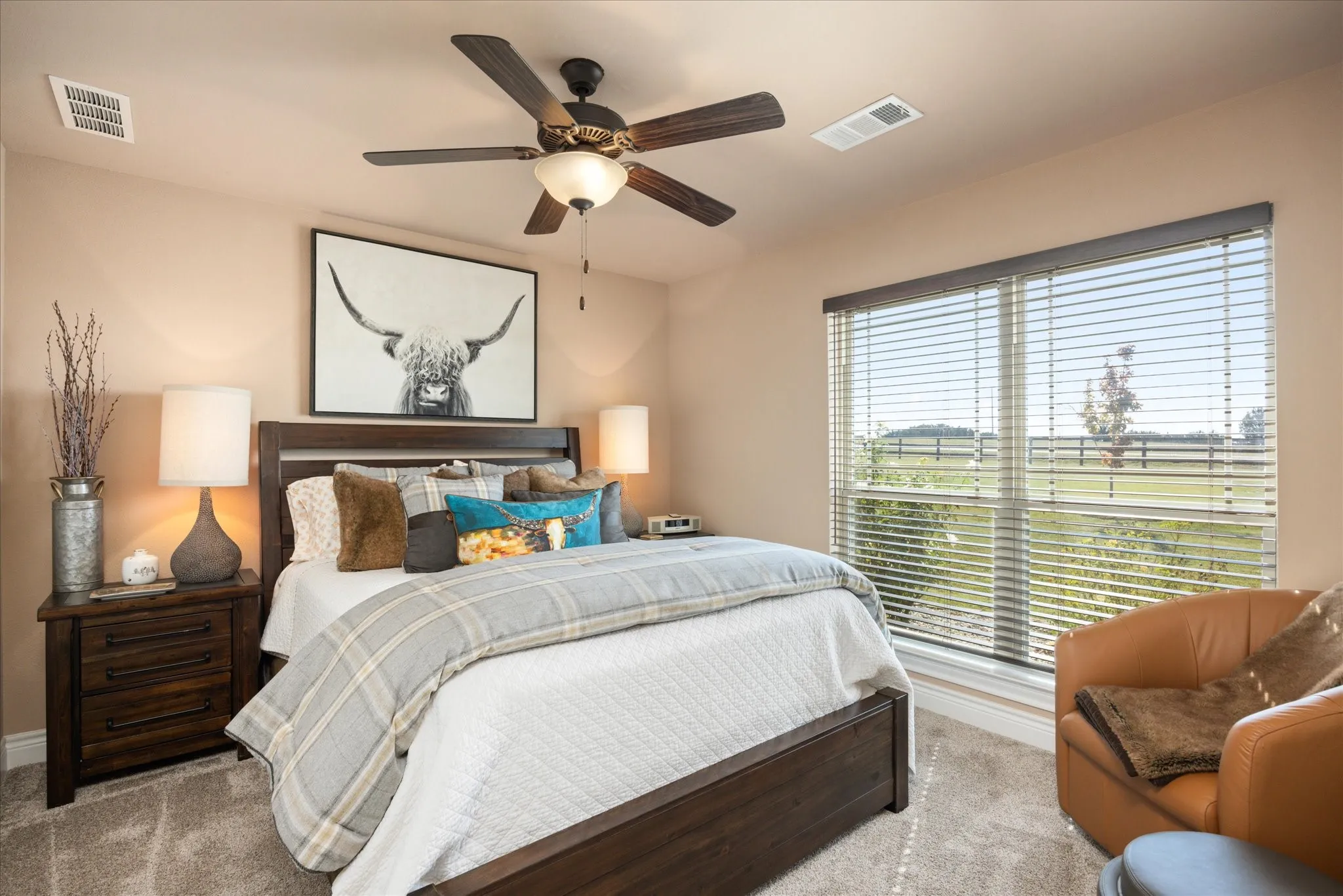 Carpeted bedroom featuring a dark wood bed frame, matching nightstands, a ceiling fan with integrated lighting, and a large window with blinds
