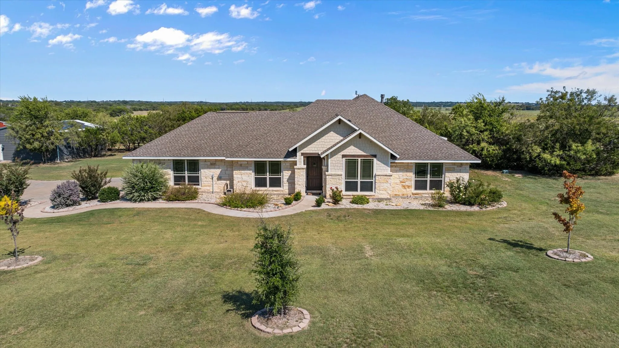Stone and siding exterior with a shingled roof