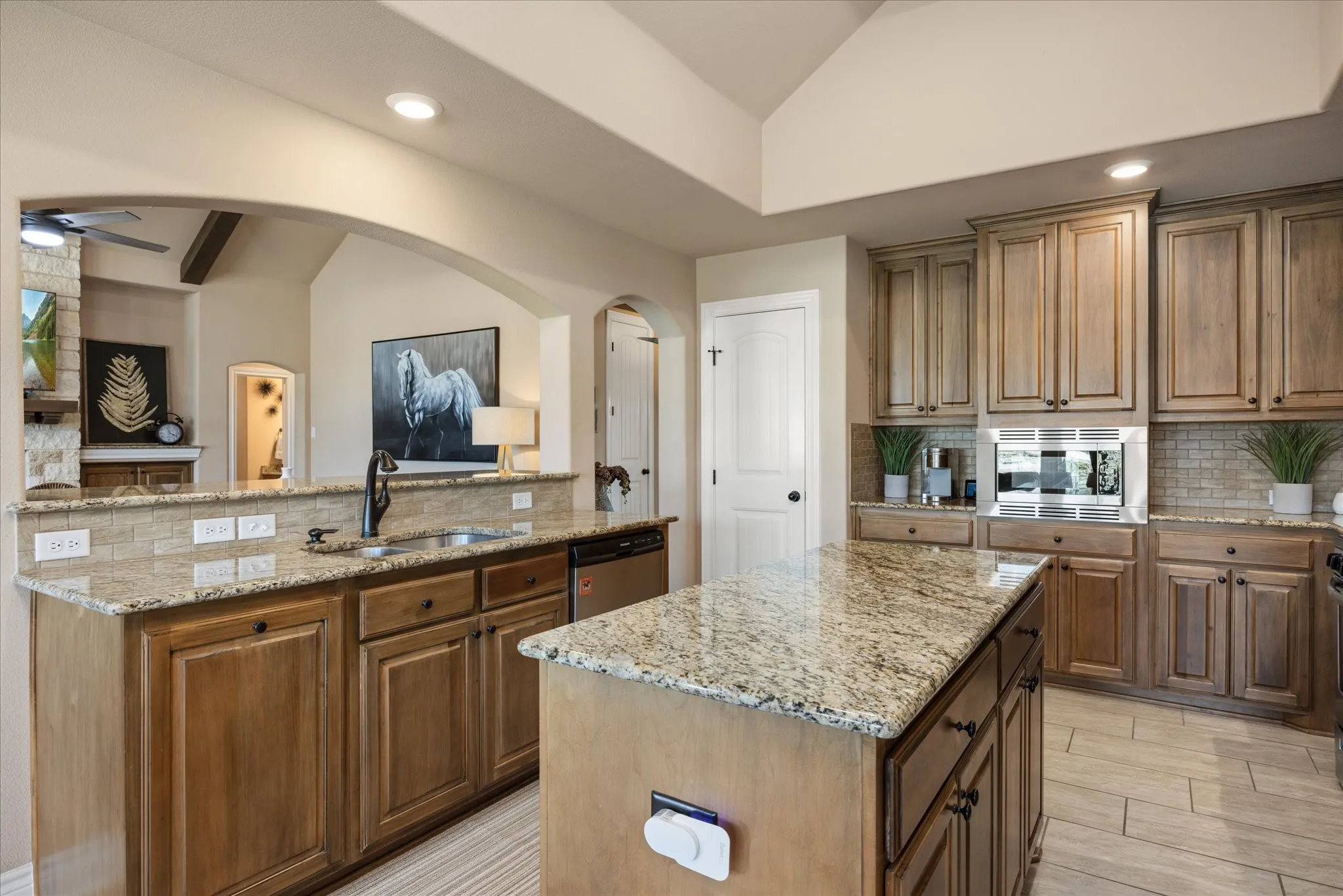 Kitchen featuring wood cabinetry, granite countertops, tile flooring, and a stone backsplash