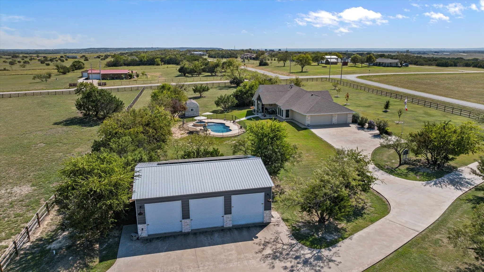 Expansive property with a circular driveway, detached three-car garage, and a swimming pool