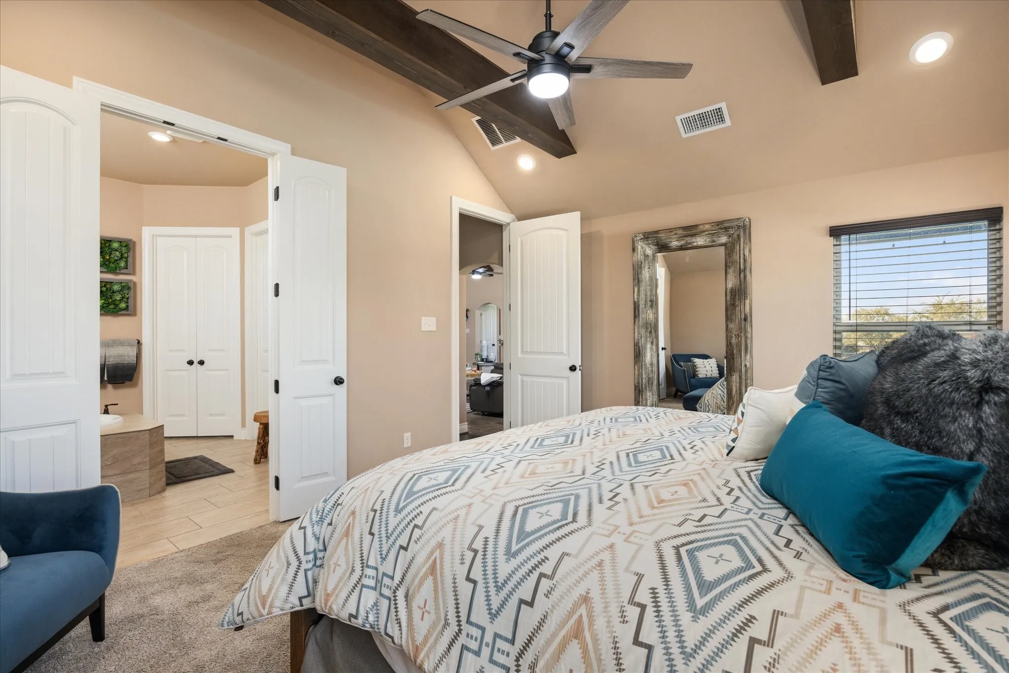 Vaulted ceiling with exposed wood beams, ceiling fan with integrated lighting, wood-finish window blinds, and recessed lighting