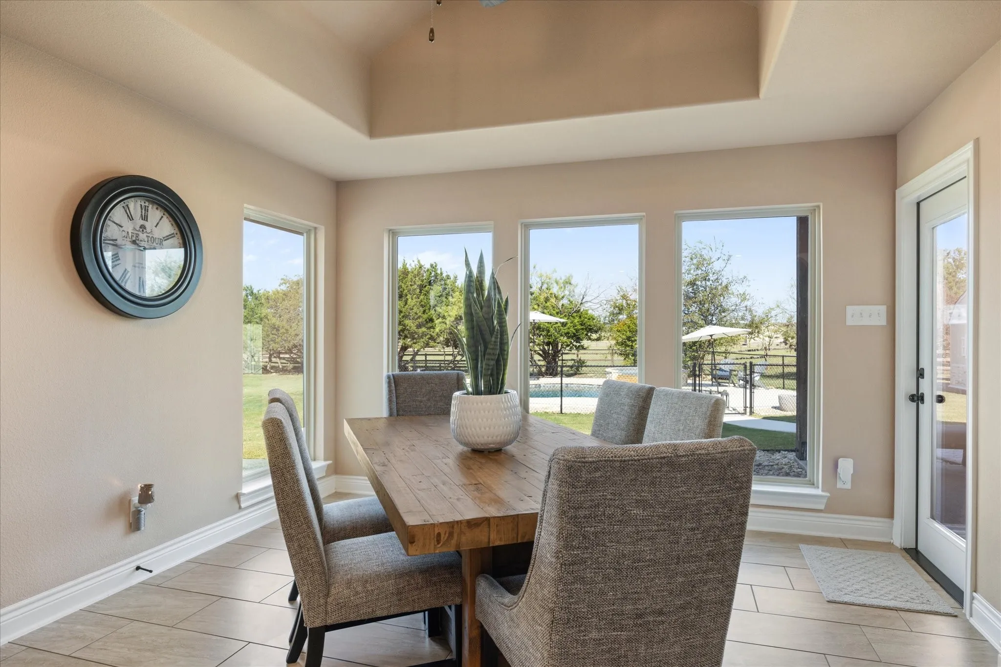 Tray ceiling, tile flooring, and multiple large windows