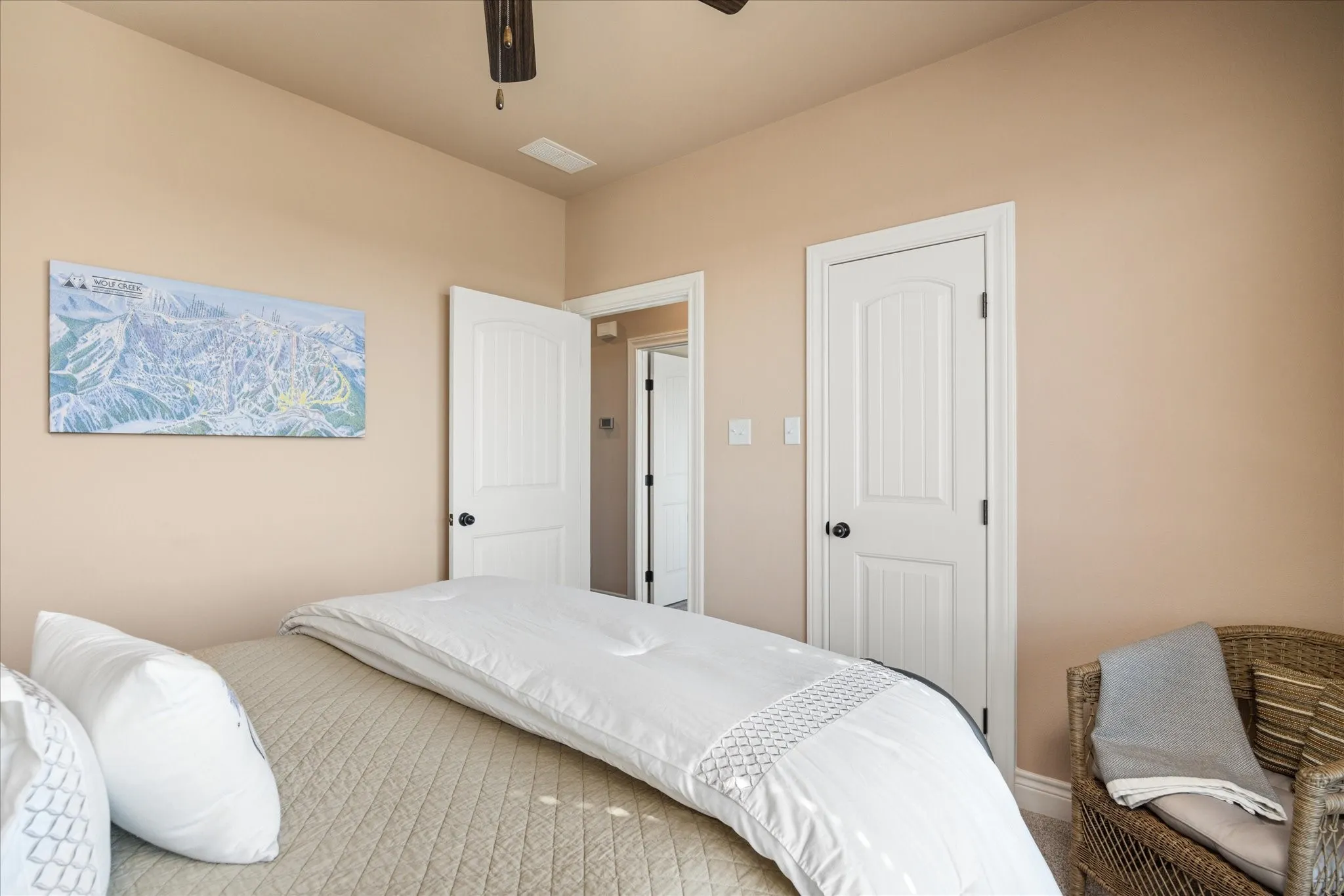 Neutral-toned walls complement white paneled doors with matte black hardware