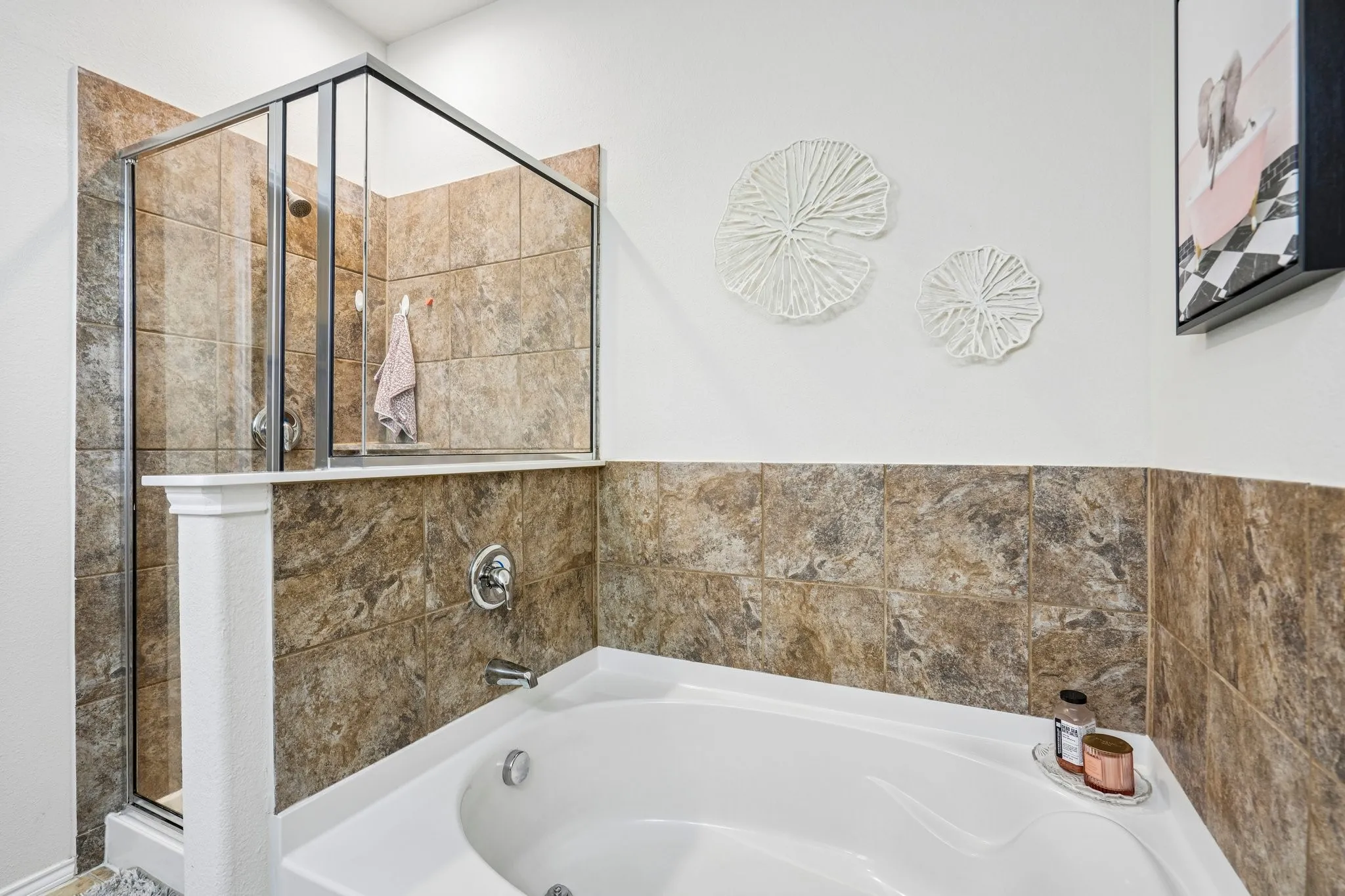 White drop-in soaking tub with chrome fixtures, tiled shower enclosure with clear glass doors, and tiled​​‌​​​​‌​​‌‌​‌‌​​​‌‌​‌​‌​‌​​​‌​​ wainscoting