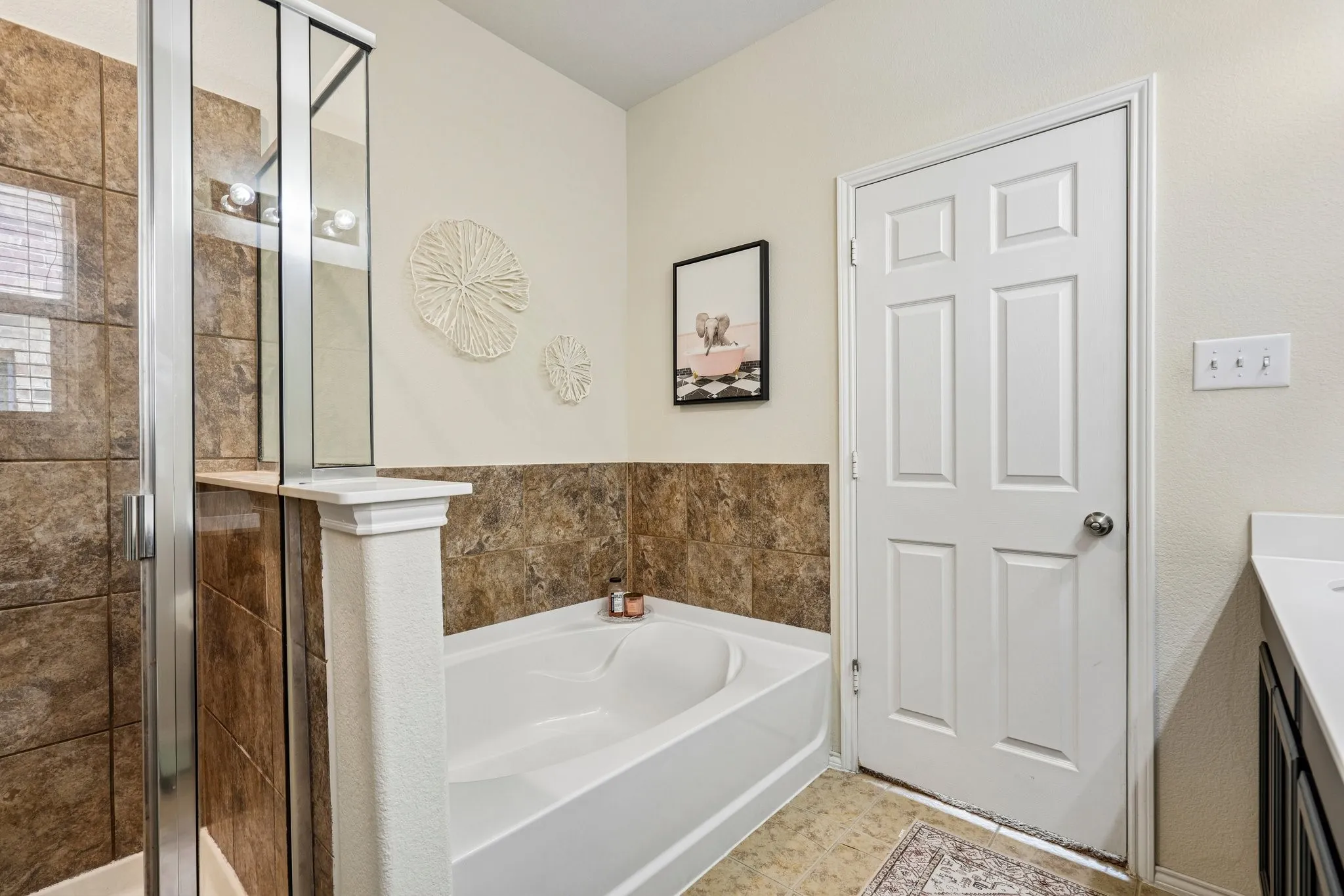 Enclosed shower with glass panel, built-in bathtub, and paneled door