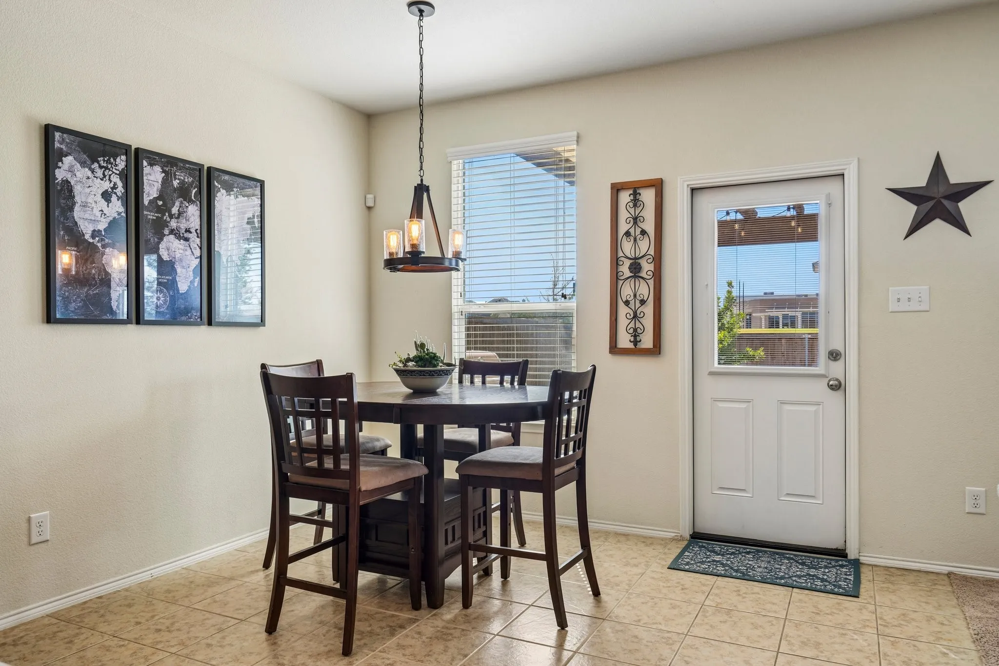 Bright eat-in kitchen featuring tile flooring, a pendant light fixture, and direct access to the exterior