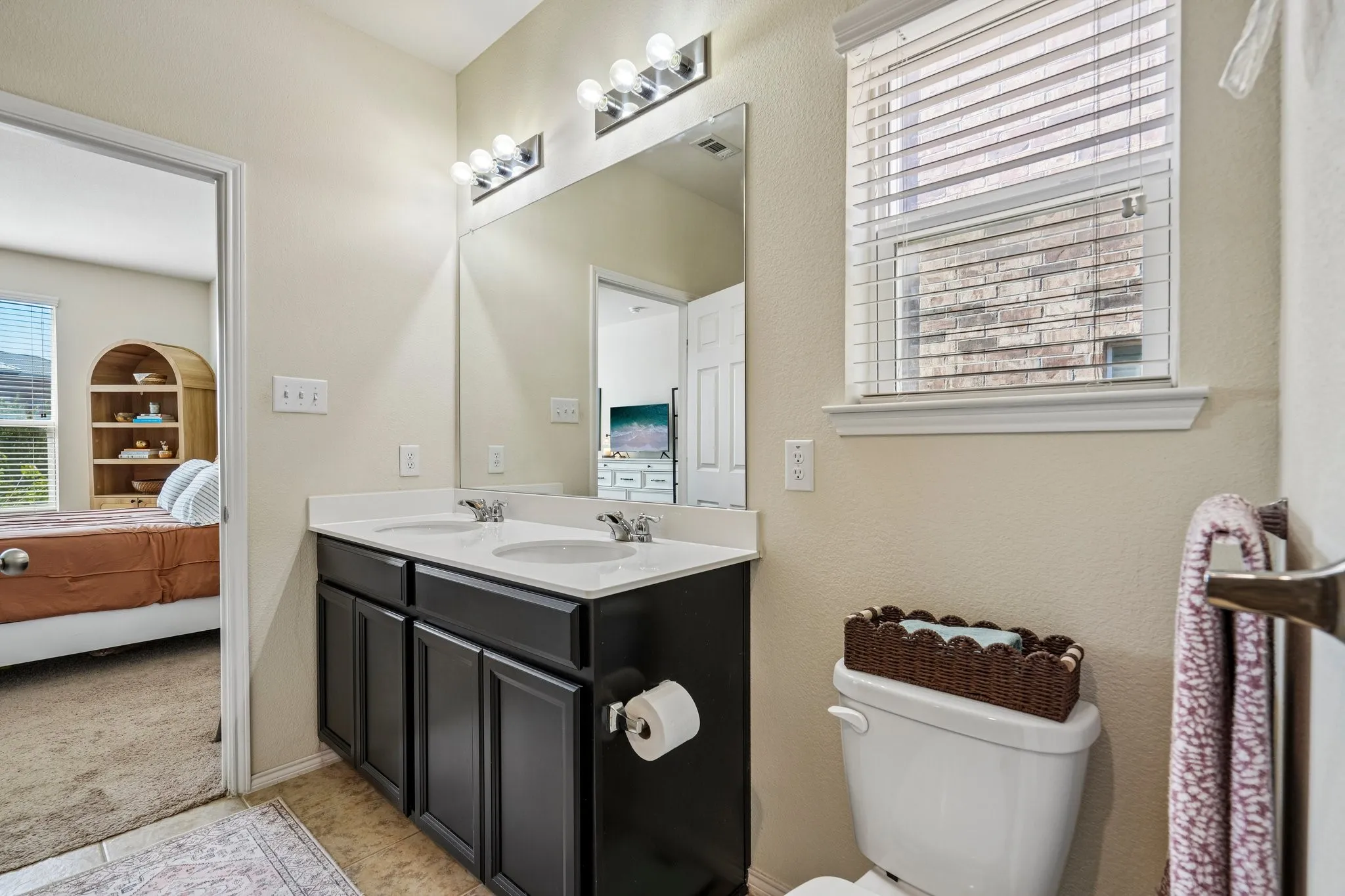 Dual vanity with dark wood-finish cabinetry, white countertop, and chrome fixtures
