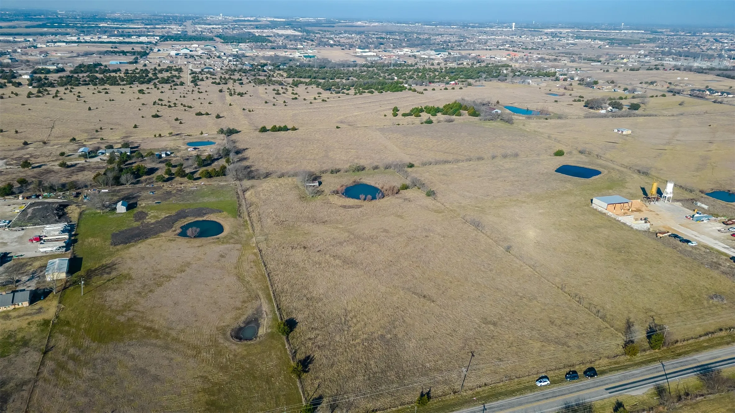 Expansive acreage featuring a highway frontage, and distant urban elements