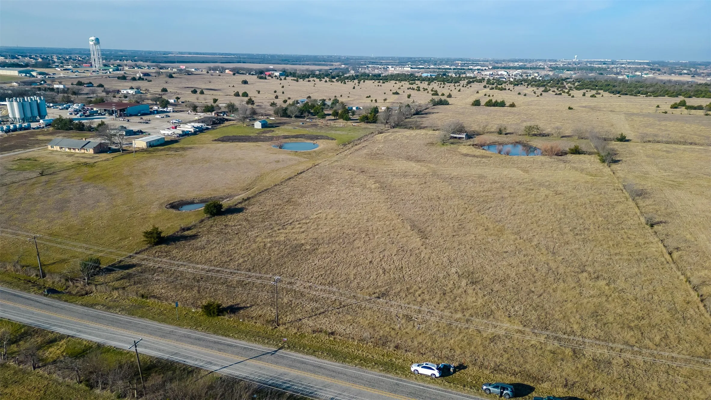 Expansive undeveloped land featuring   distant infrastructure
