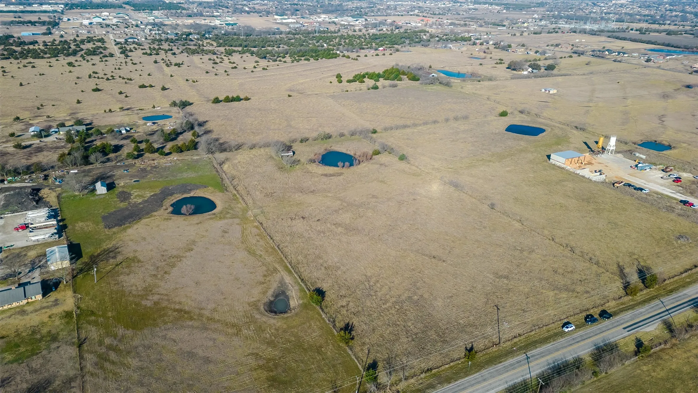 Expansive acreage featuring a substantial road frontage, and a distant tree line