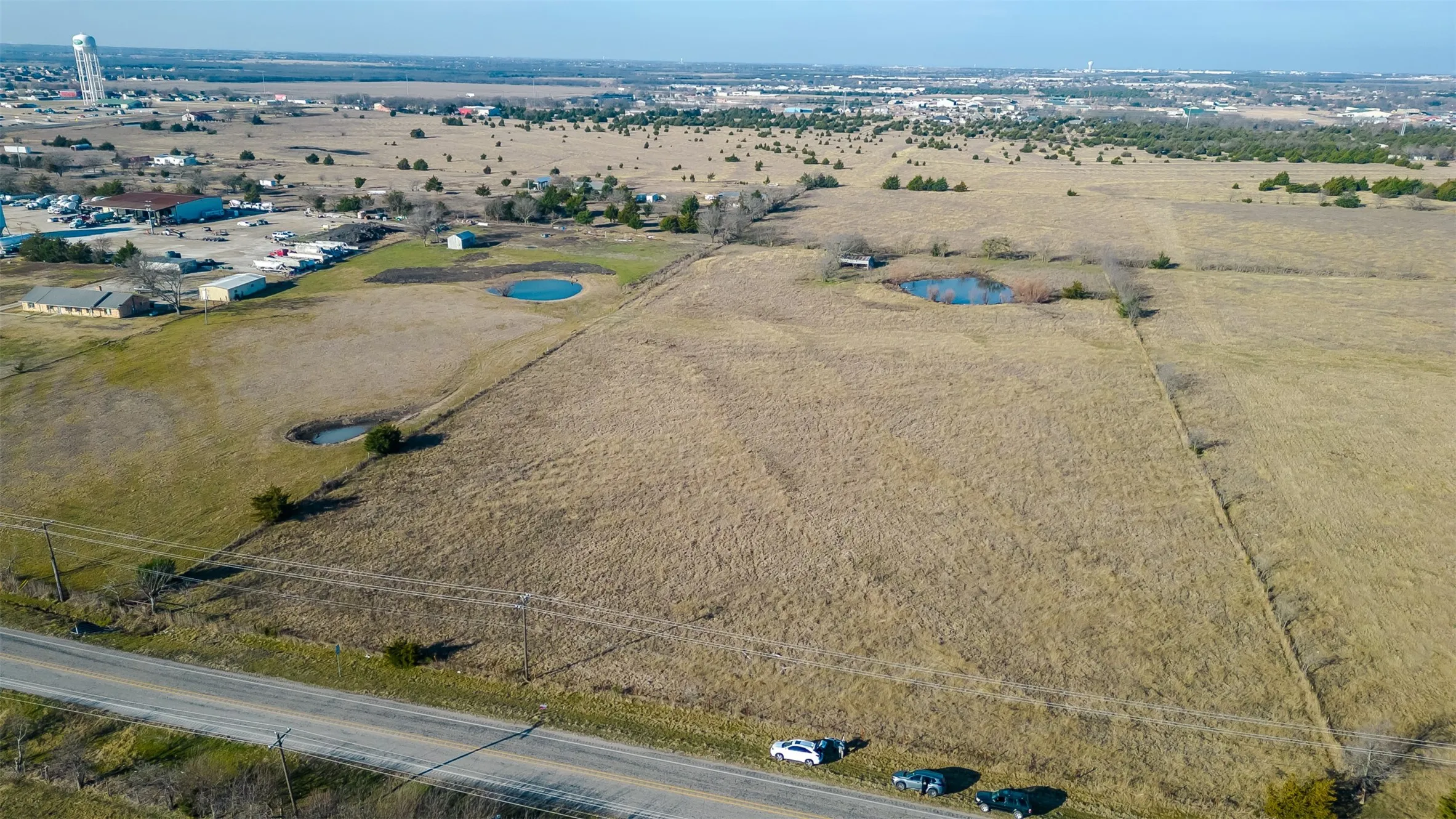 Expansive land parcel featuring open fields, and established fence lines