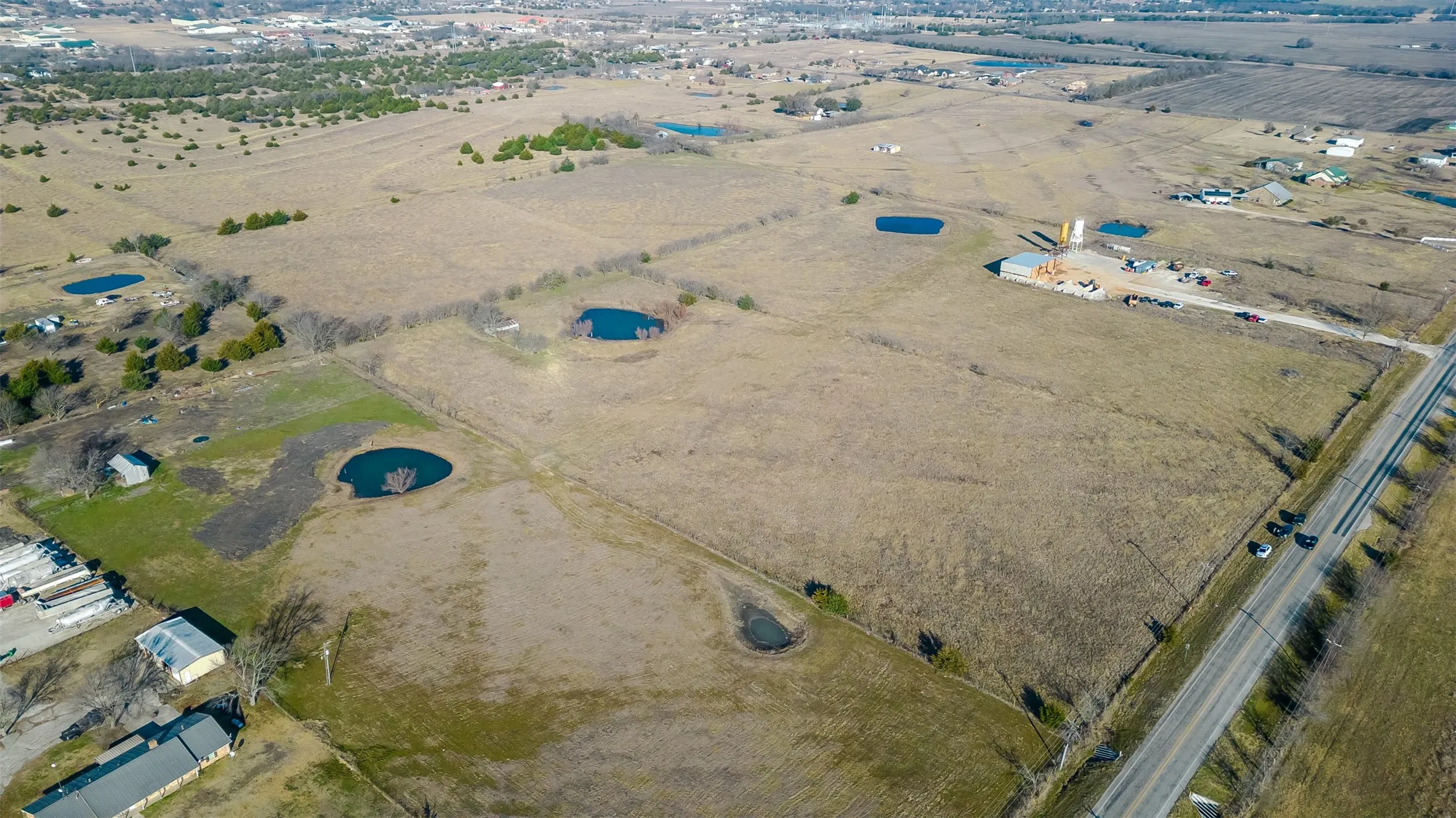 Expansive land with a paved roadway bordering the property