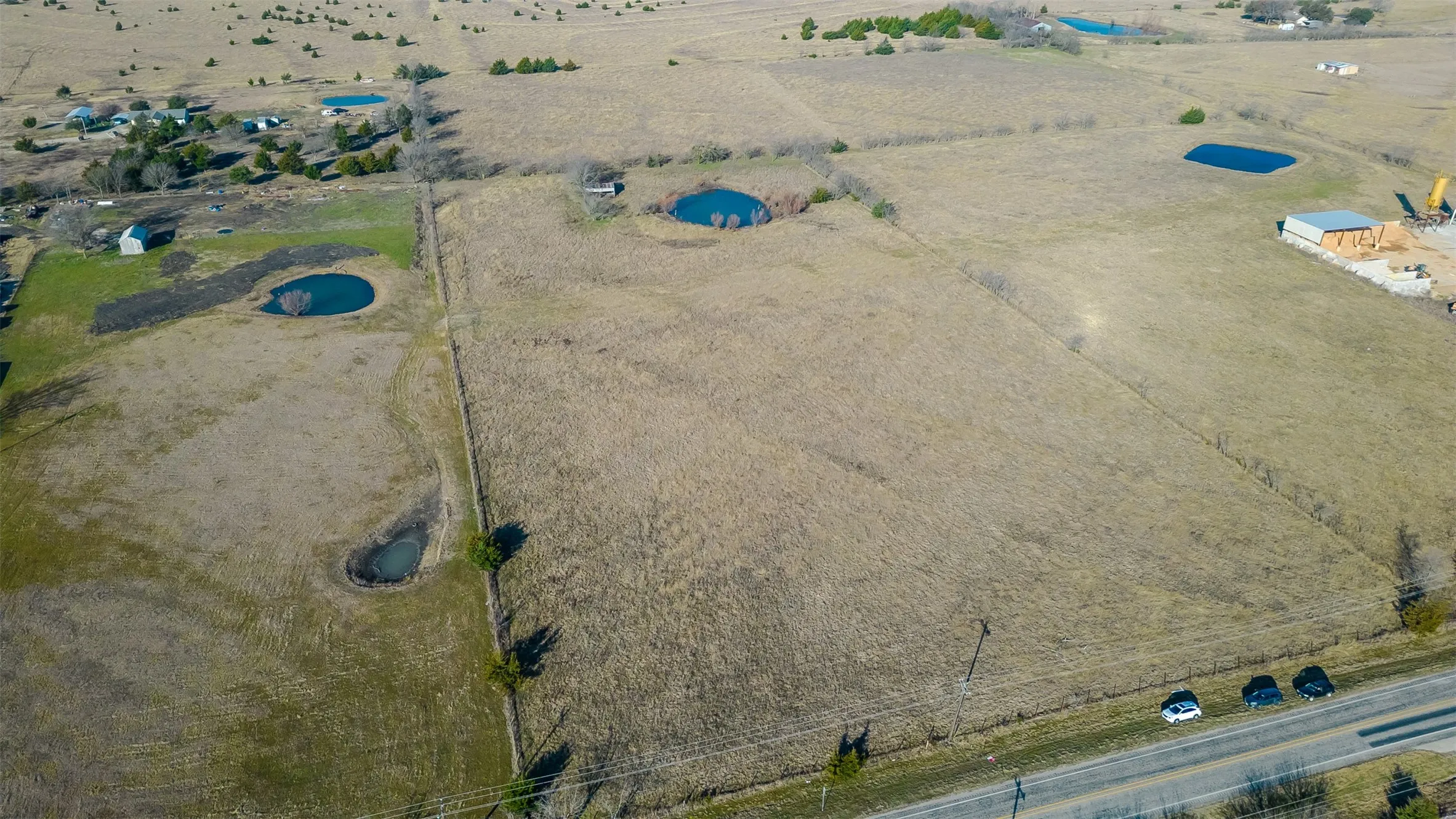 Expansive acreage featuring mature trees, and a paved road frontage