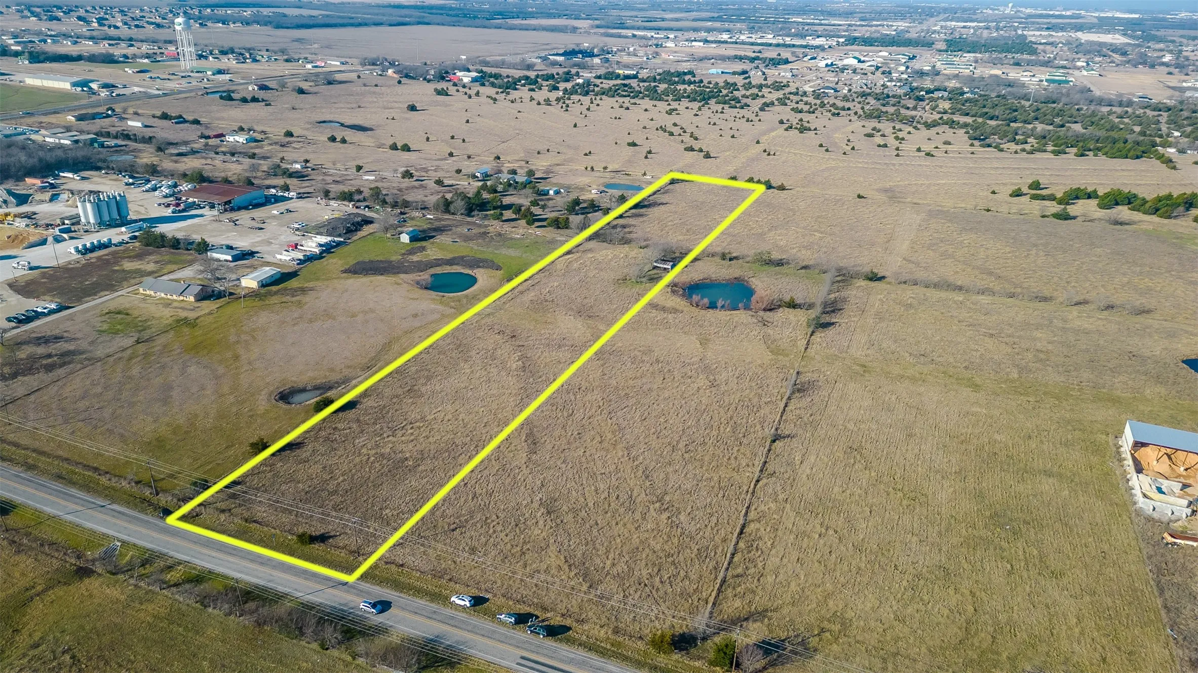 Expansive undeveloped land featuring a long, rectangular lot with direct road frontage