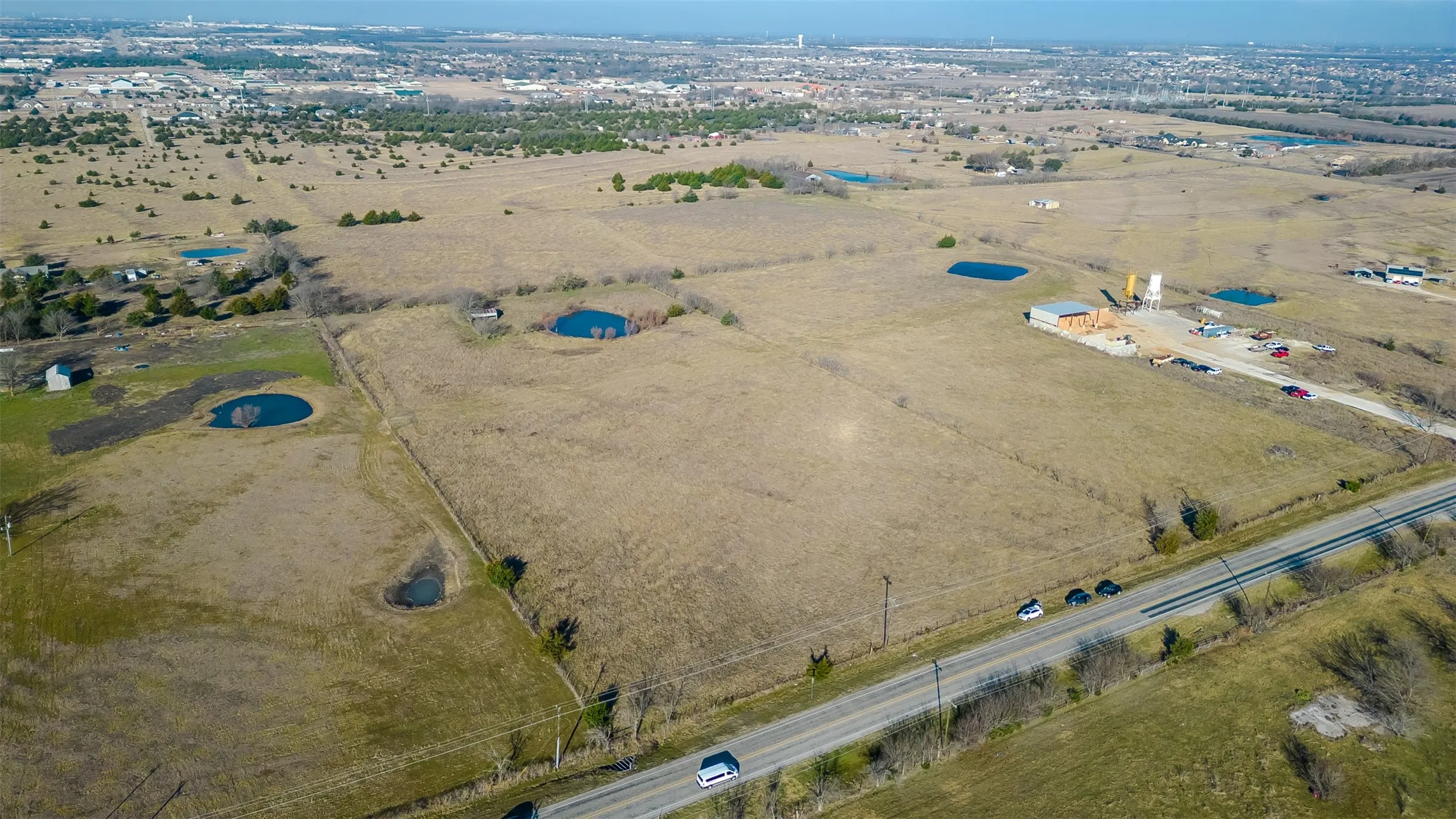 Expansive acreage featuring , a paved road frontage, and a distant urban landscape