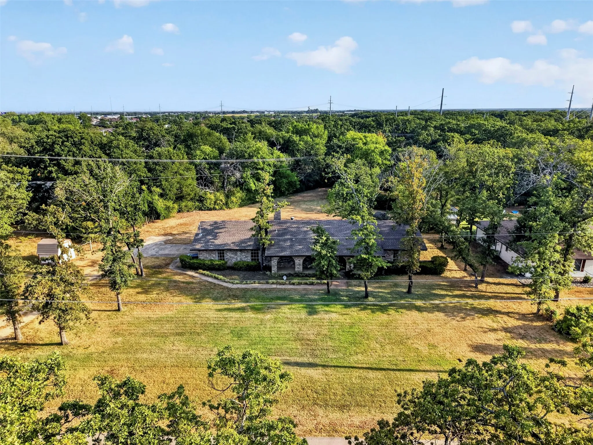 surrounded by mature trees in an established neighborhood.