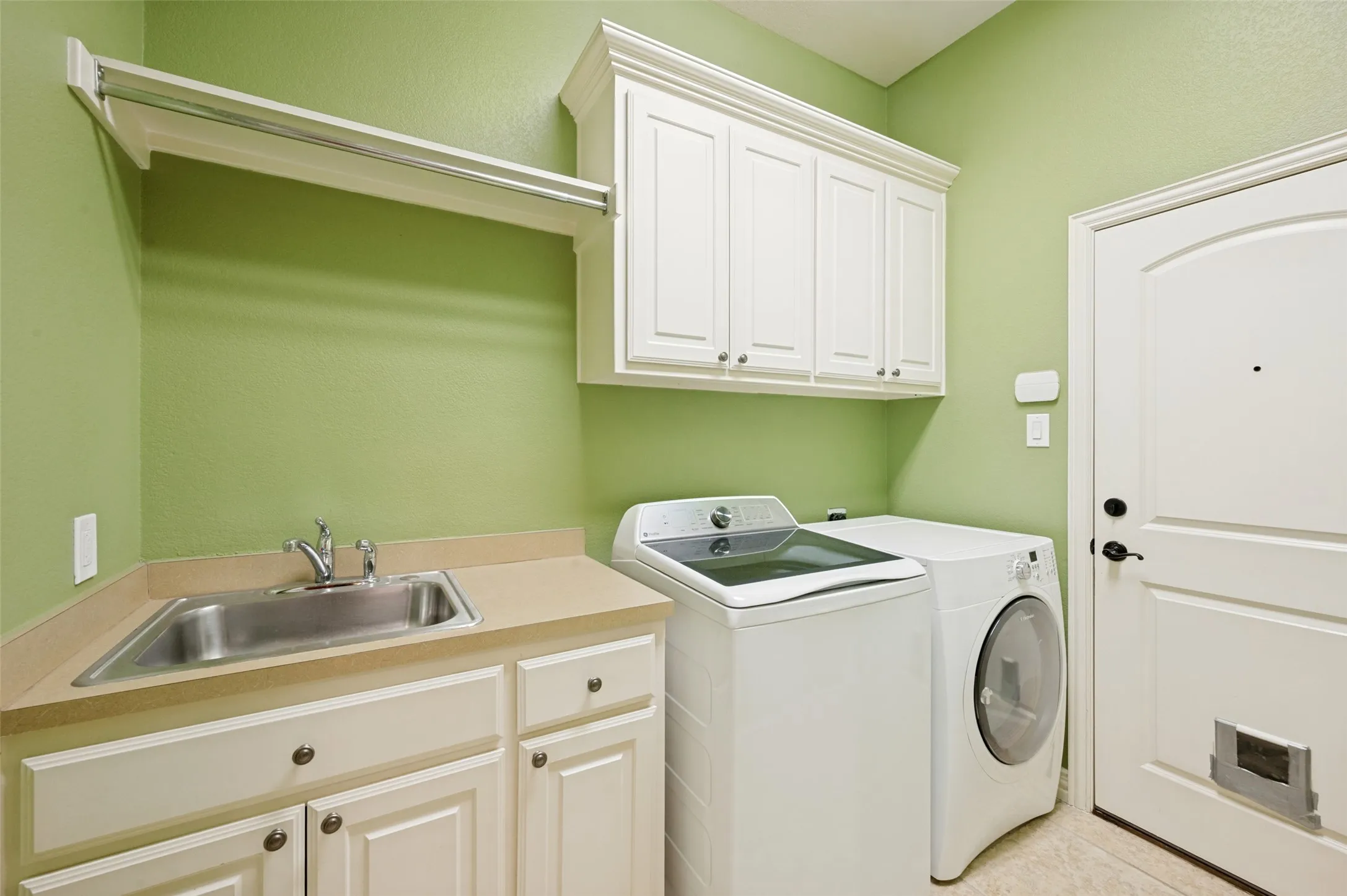 Stainless steel utility sink, ample cabinetry, and countertop space