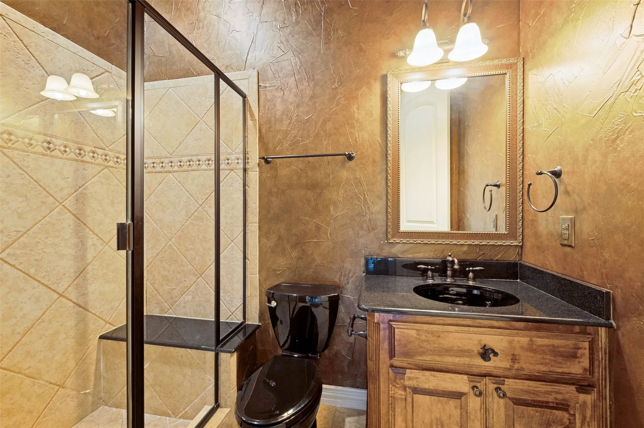Shower with tiled surround, an integrated bench, and a framed glass enclosure