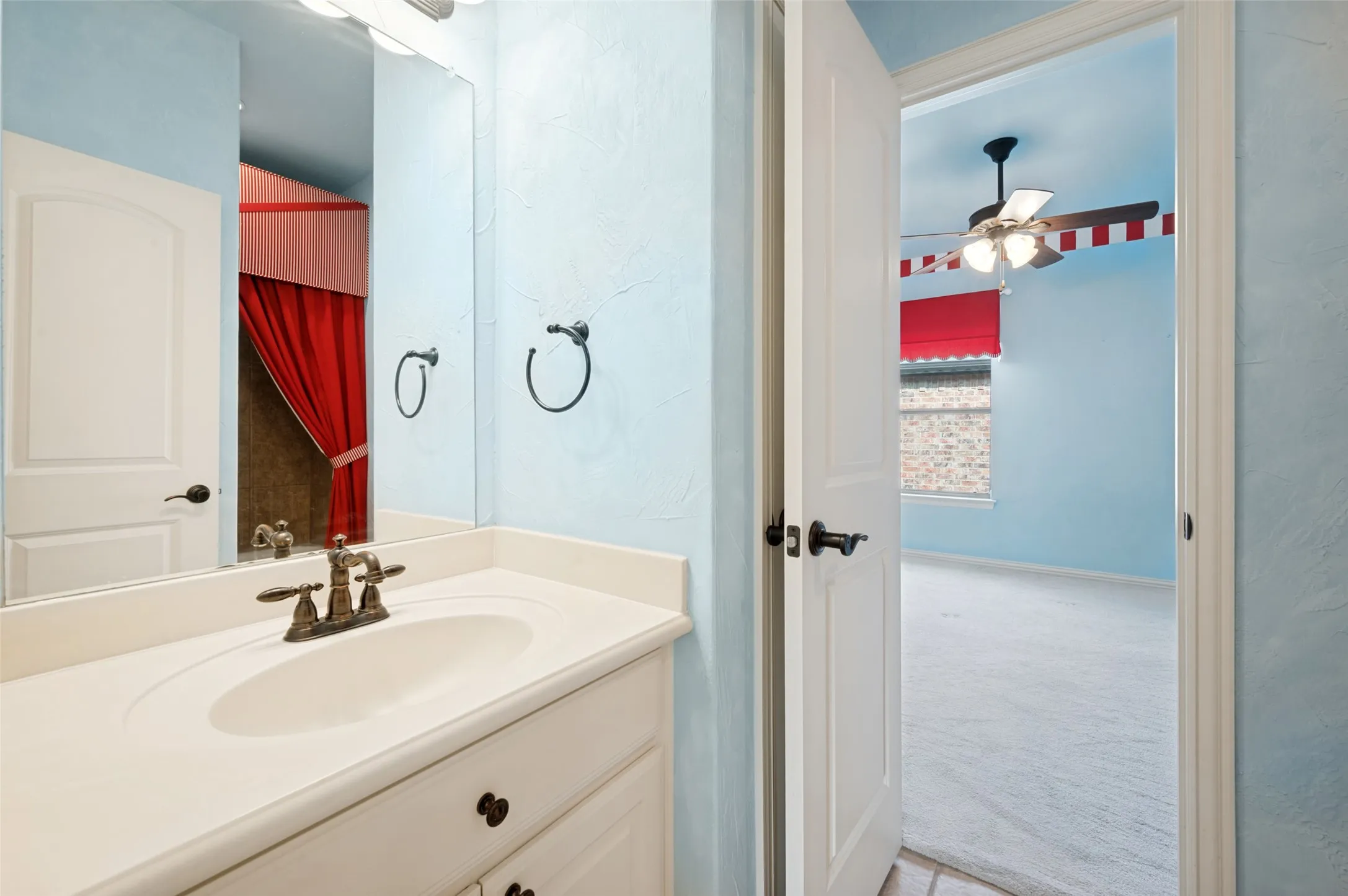 White vanity with integrated sink, brass-finish faucet, and coordinating hardware