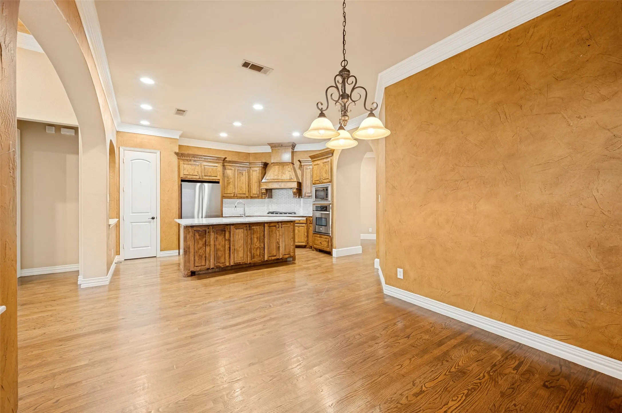 Kitchen with wood-finish flooring, recessed lighting, and a decorative chandelier