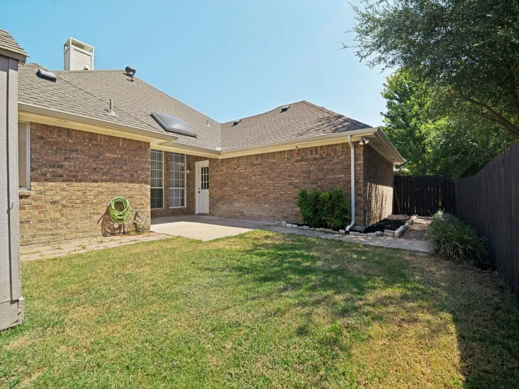 Brick exterior with a shingle roof and a skylight