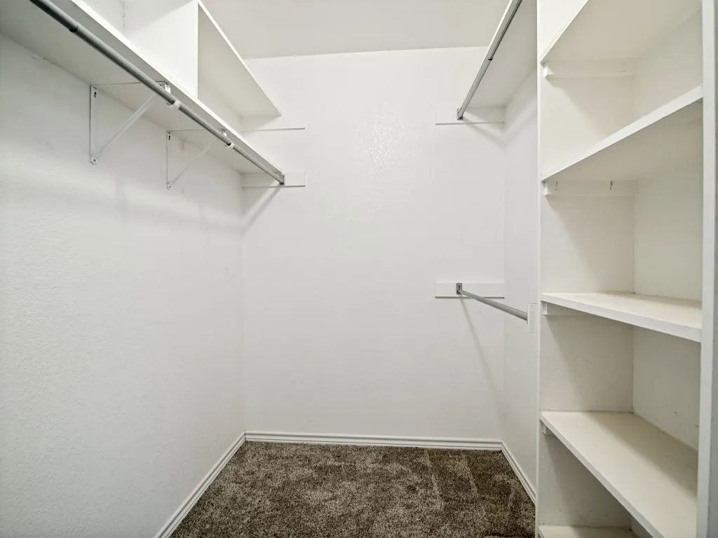 Integrated shelving and hanging rods provide organizational options within this space