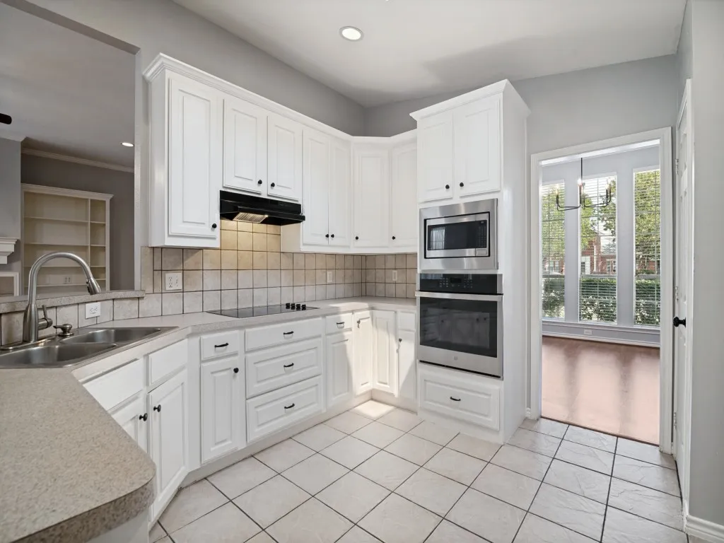Kitchen featuring white cabinetry, tile flooring, stainless steel appliances, and a built-in oven and microwave