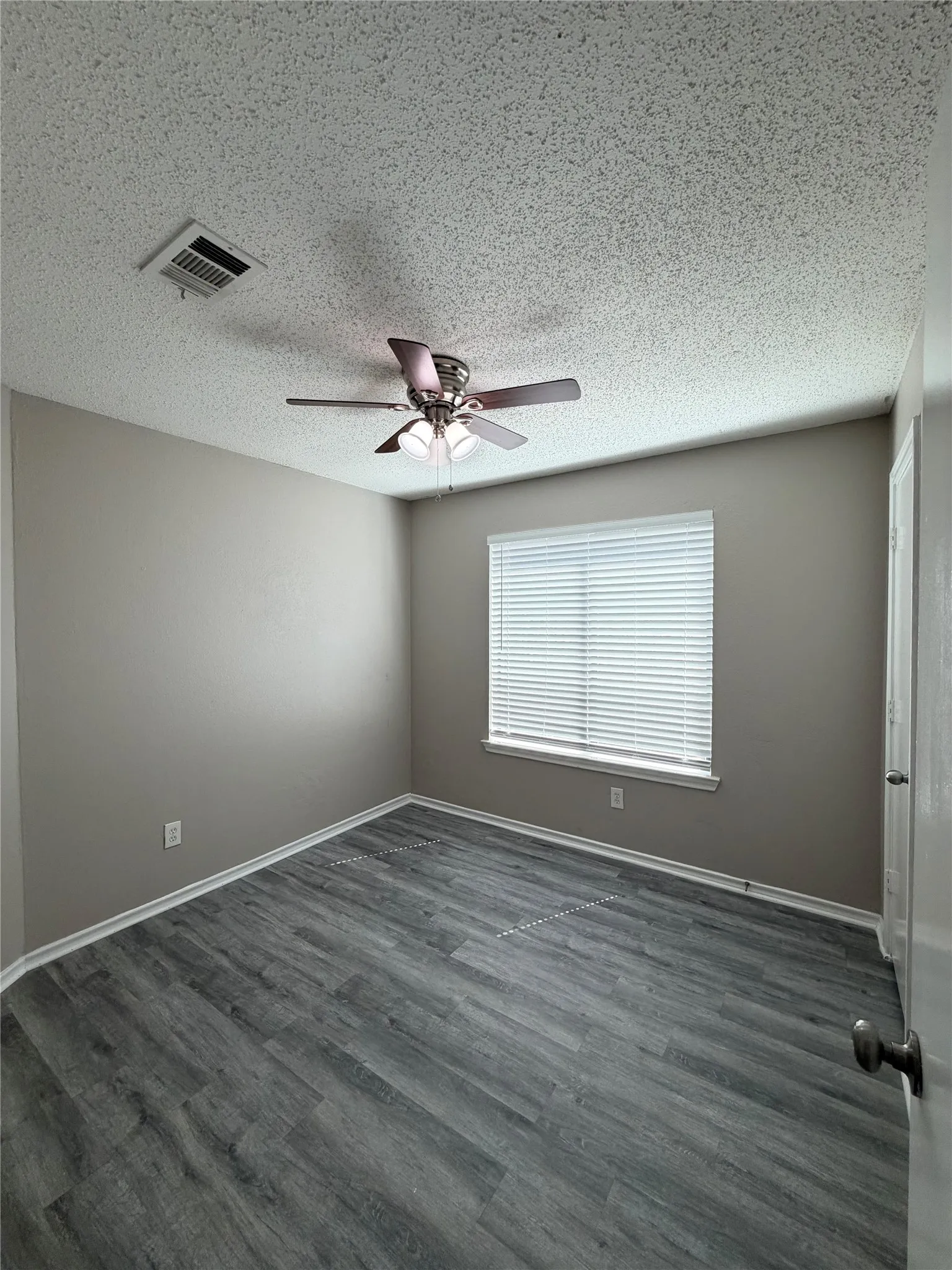 Wood-finish flooring, ceiling fan, window with blinds, and neutral wall tones