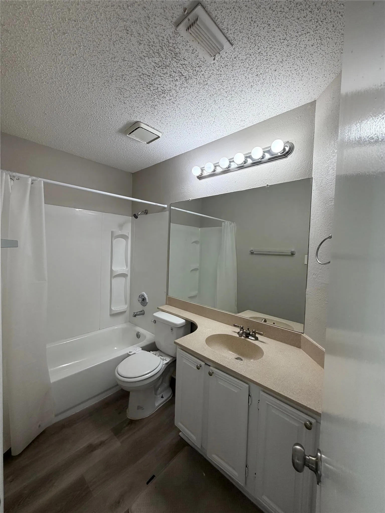 Vanity with integrated sink, white cabinetry, and a full-width mirror