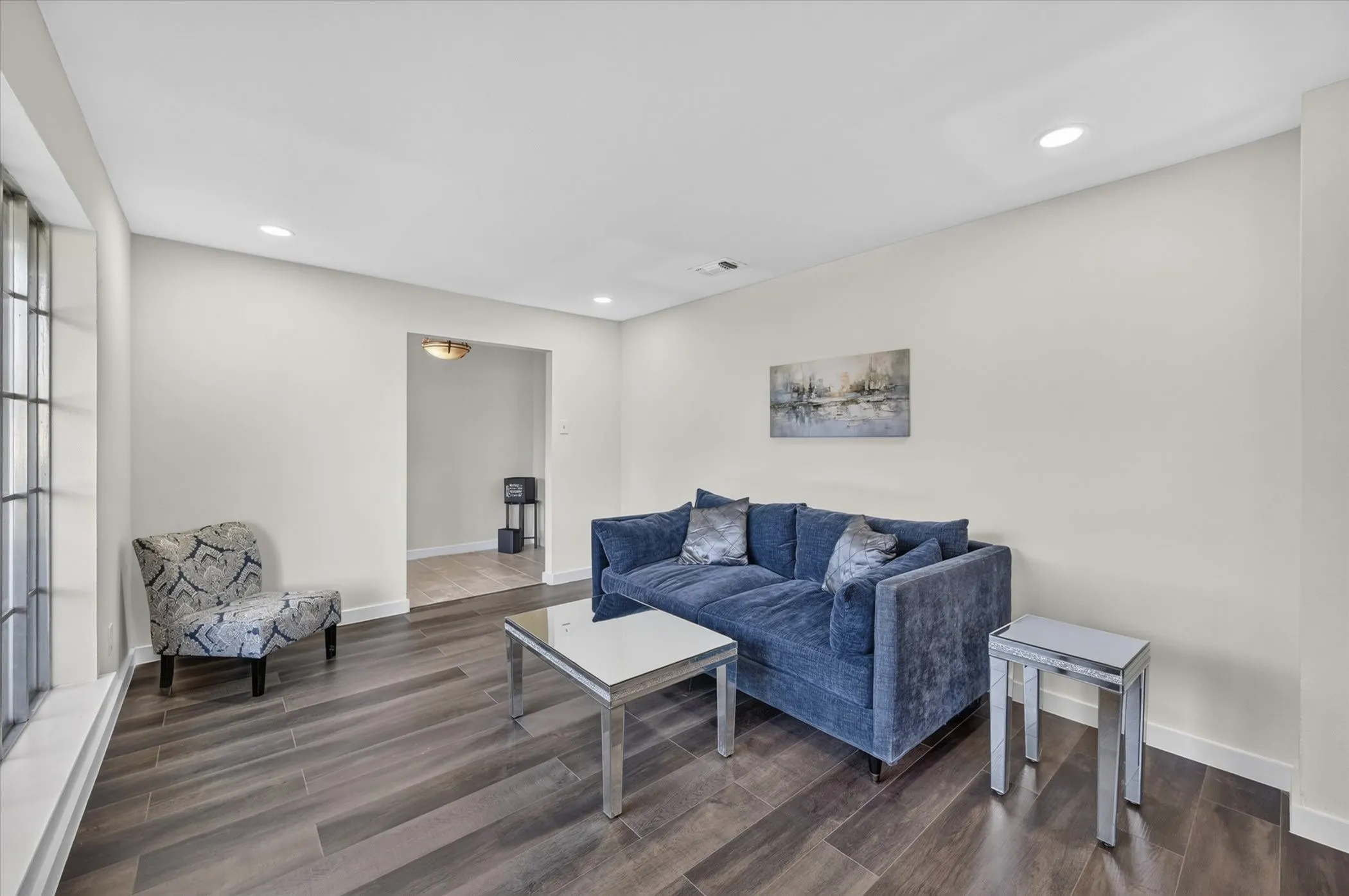Recessed lighting, wood-finish flooring, light-toned walls, and an arched entryway