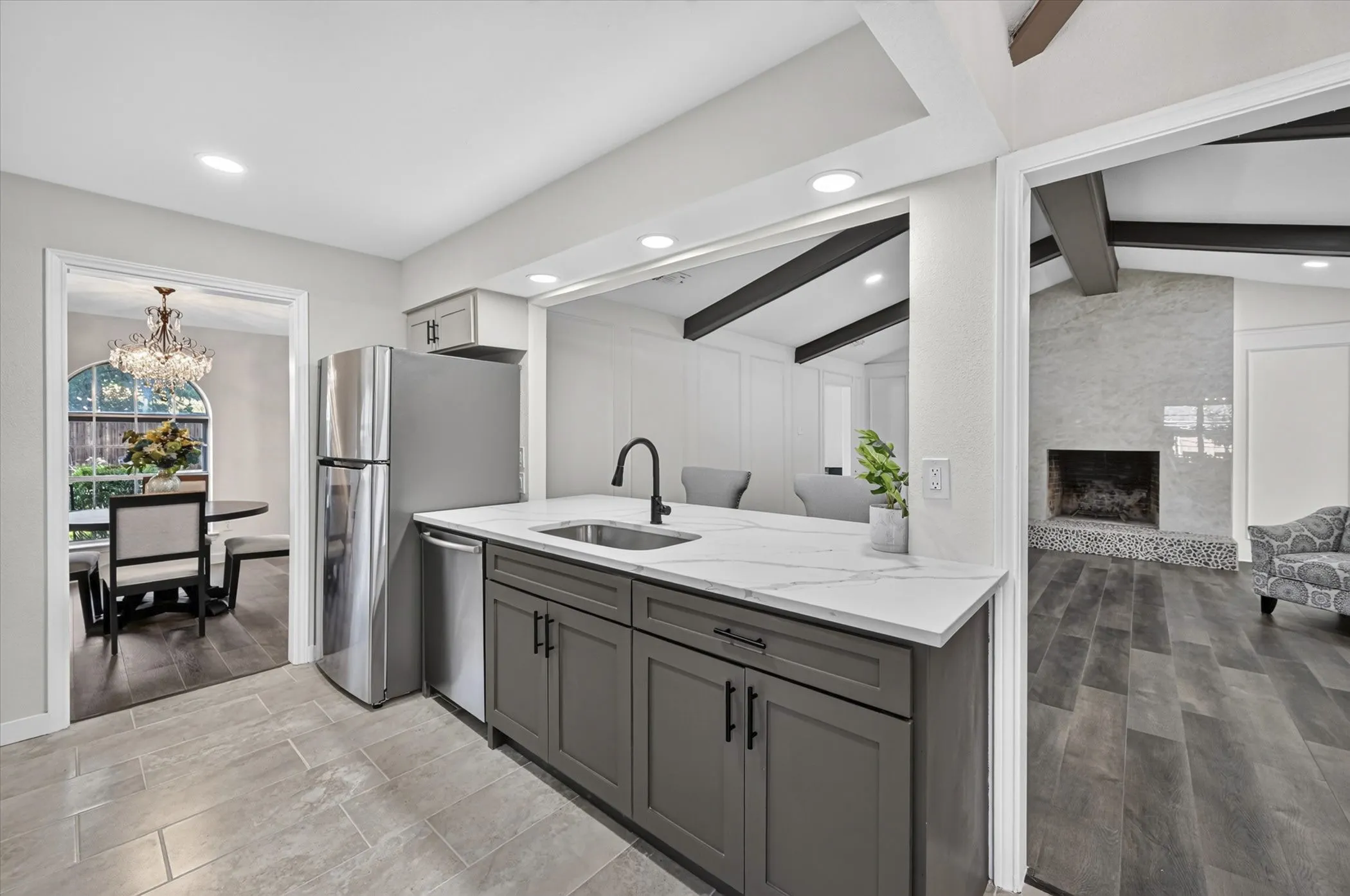 Kitchen featuring a stainless steel refrigerator, undermount sink with a matte black faucet, gray cabinetry, and a light-toned countertop