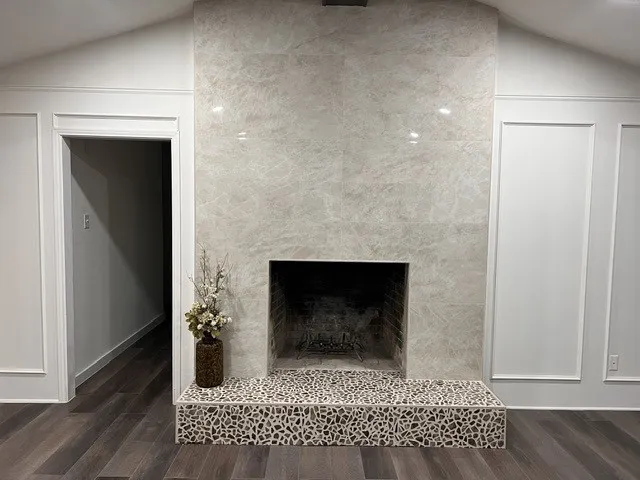 Vaulted ceiling with an accent fireplace featuring a stone-tile surround and a mosaic tile hearth