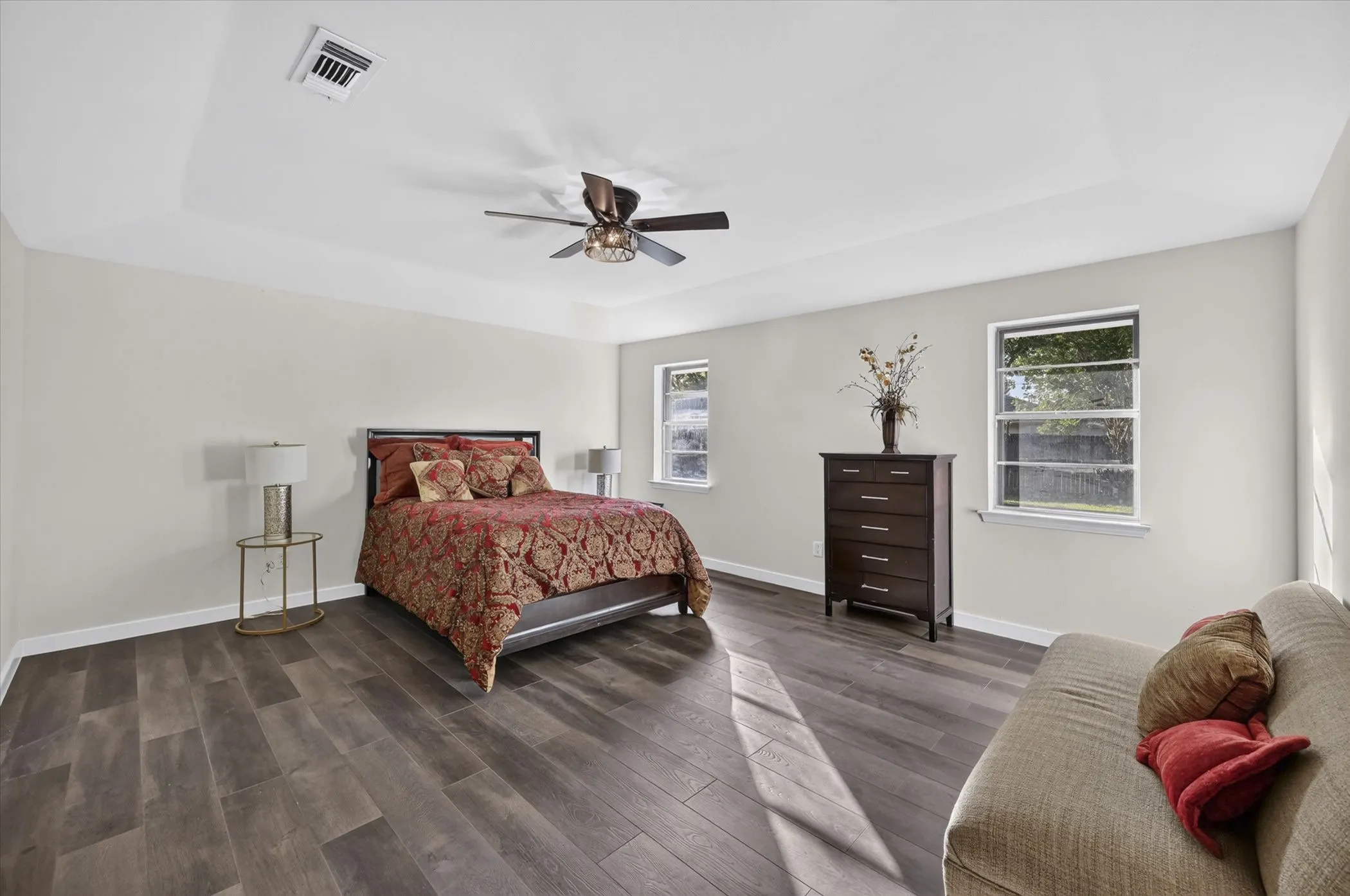 Recessed ceiling, wood-finish flooring, ceiling fan, and multiple windows