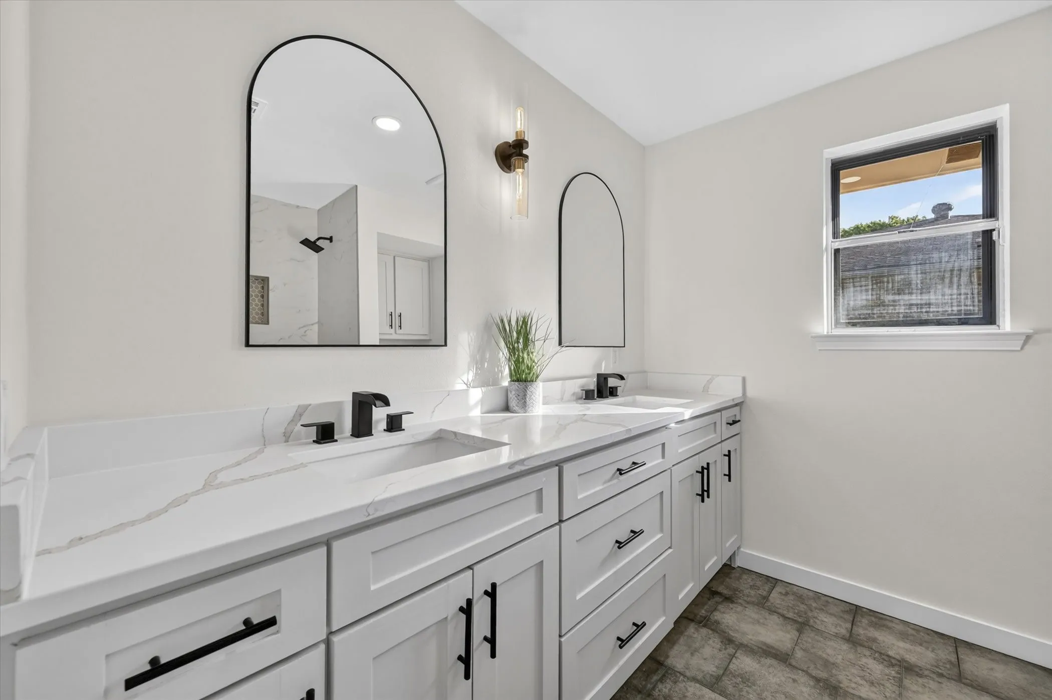 Dual vanity with white cabinetry, matte black hardware, and integrated sinks