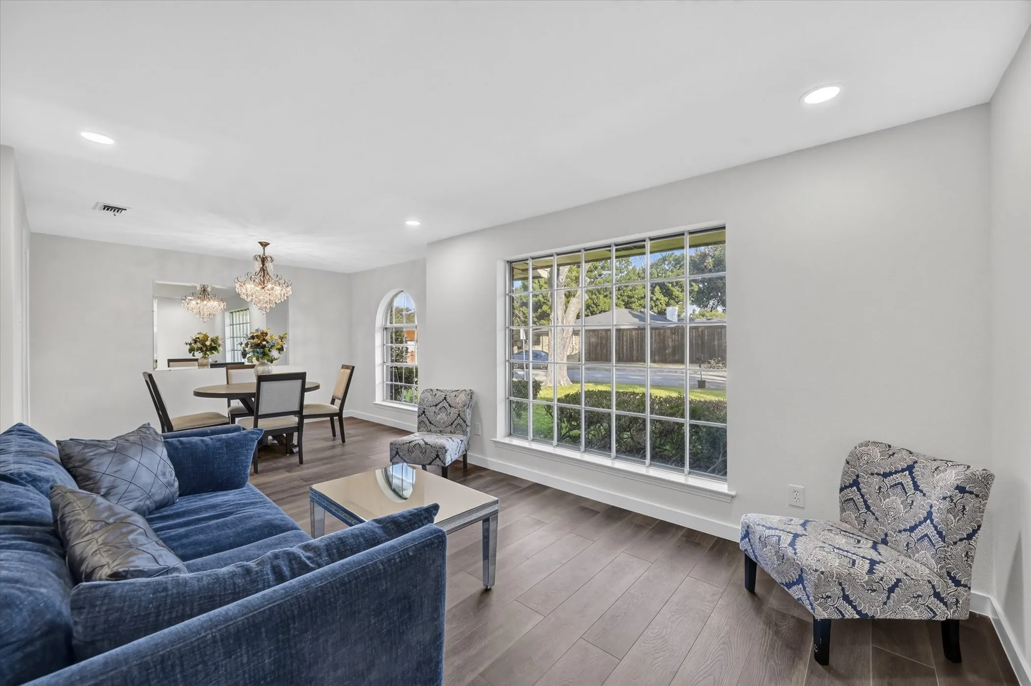 Wood-finish flooring throughout, recessed lighting, and a large grid-pattern window