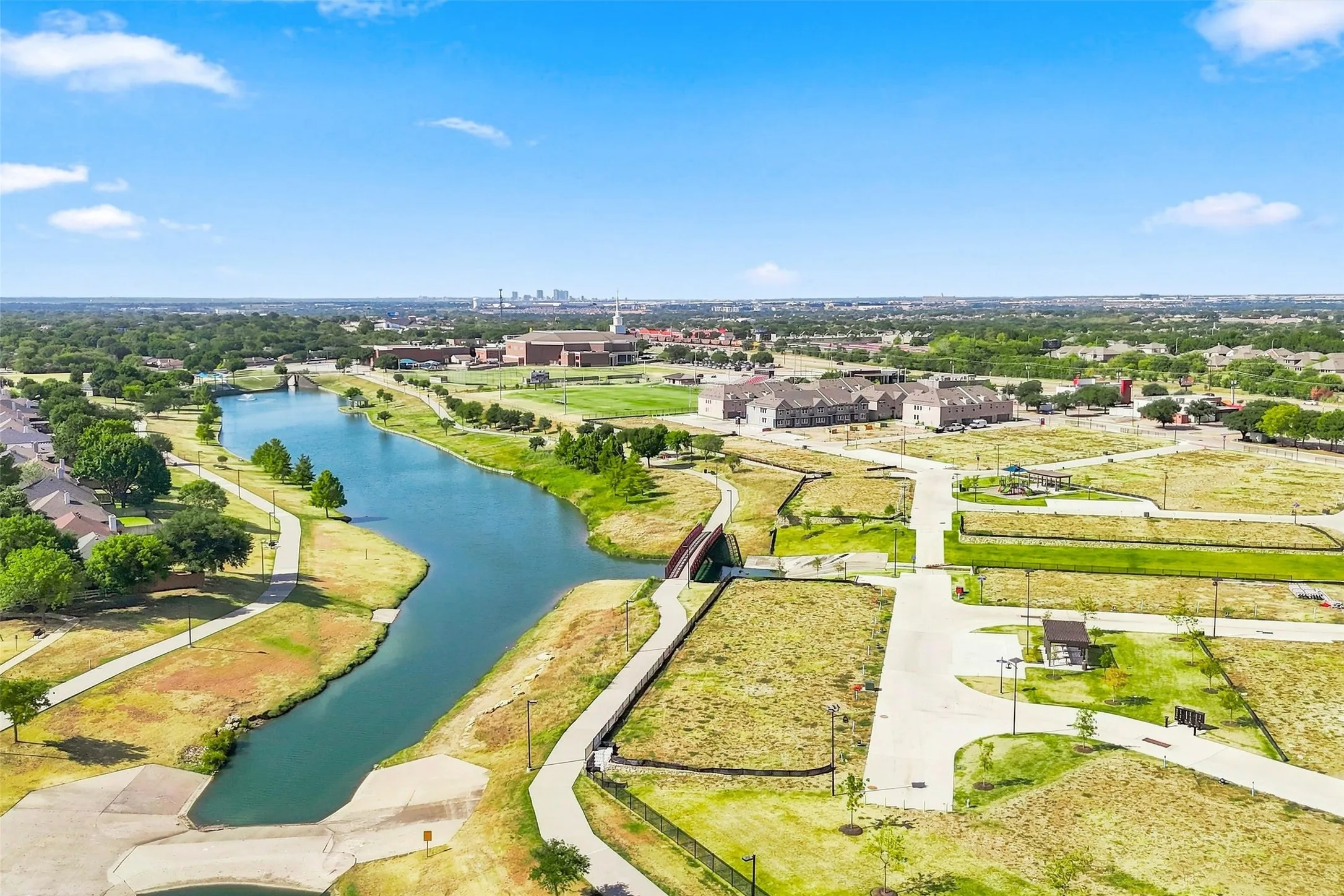 Waterfront community with paved pathways, green spaces, and bridge access