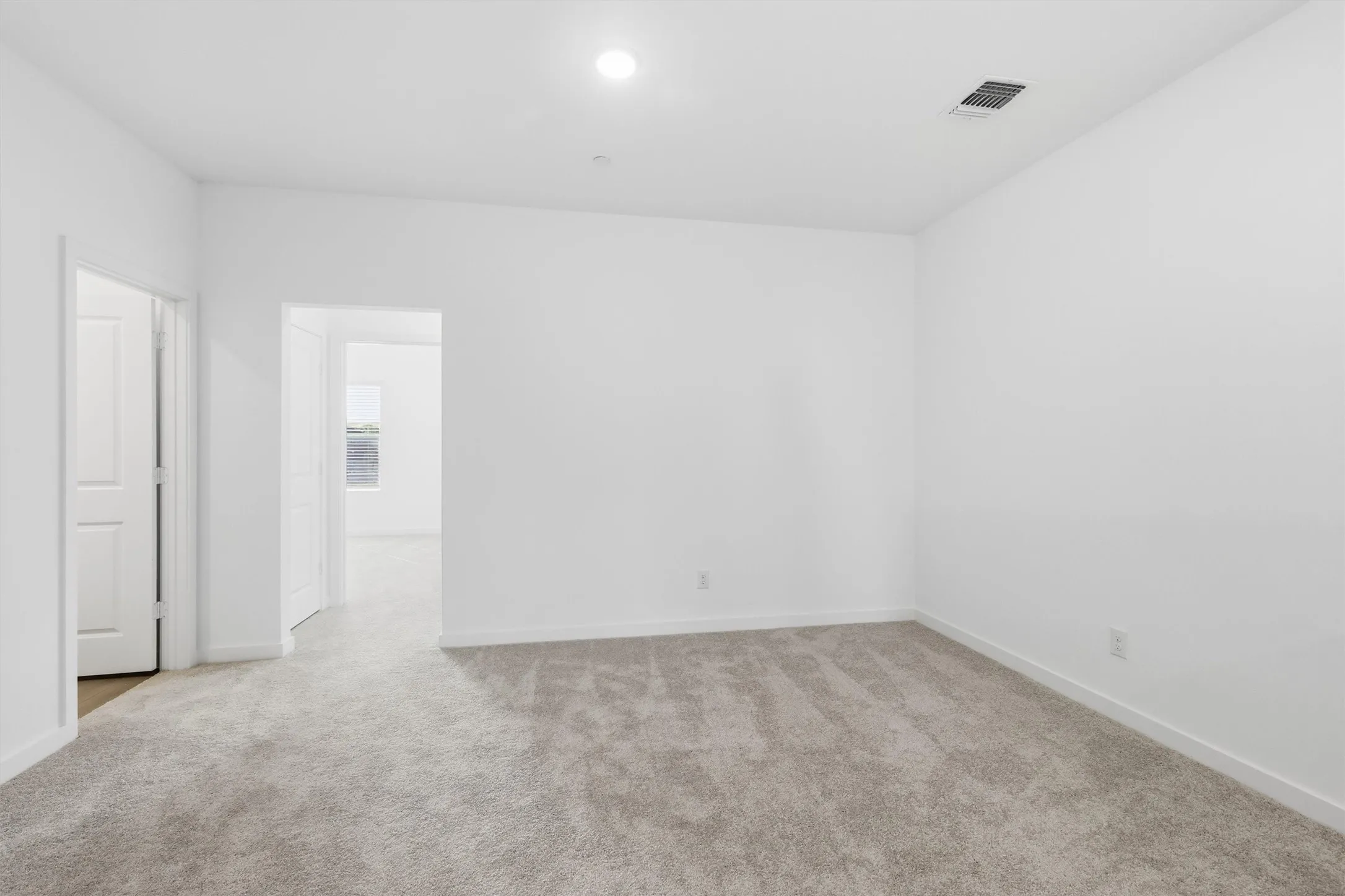 Neutral tone wall finishes, recessed lighting, and soft carpet flooring