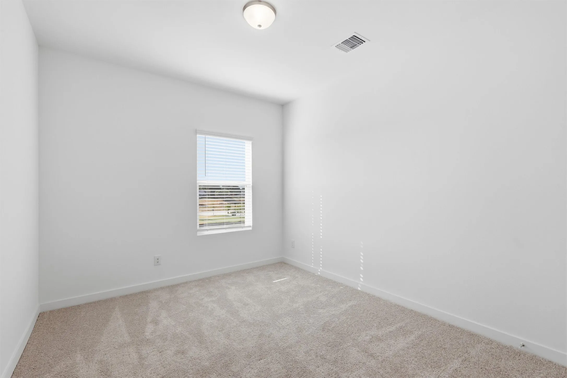 Wall-to-wall carpeting, window with blinds, ceiling-mounted light fixture, and white painted walls