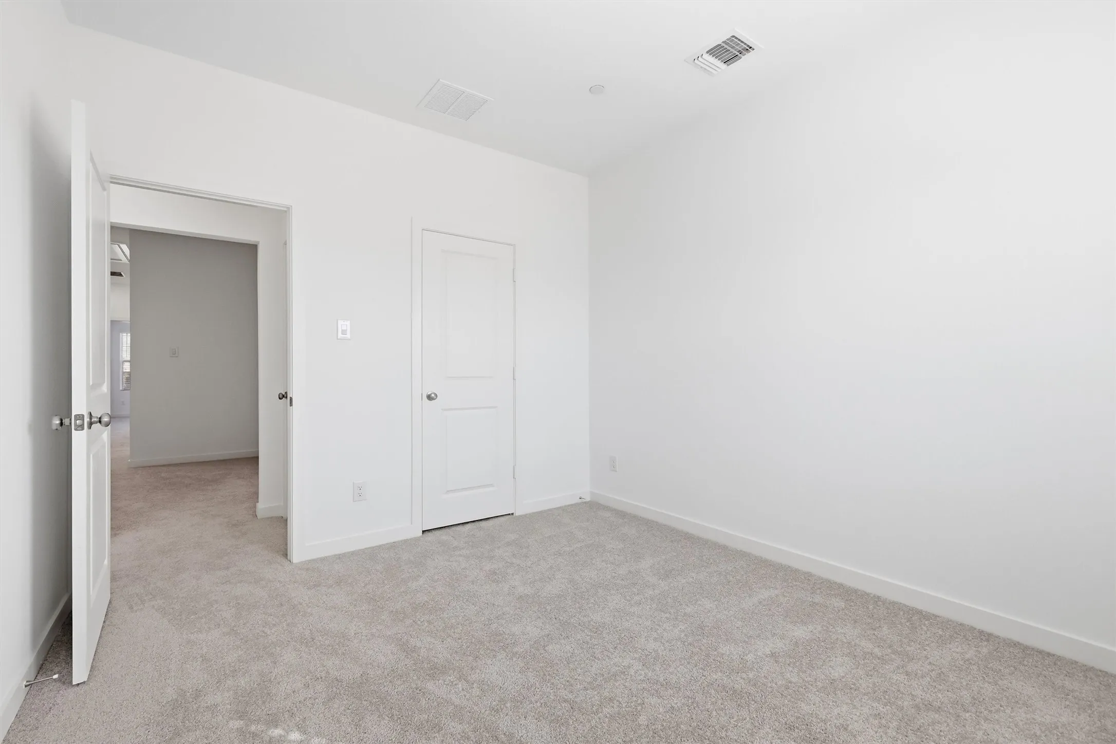 Neutral-toned carpet flooring and white painted walls create a blank canvas