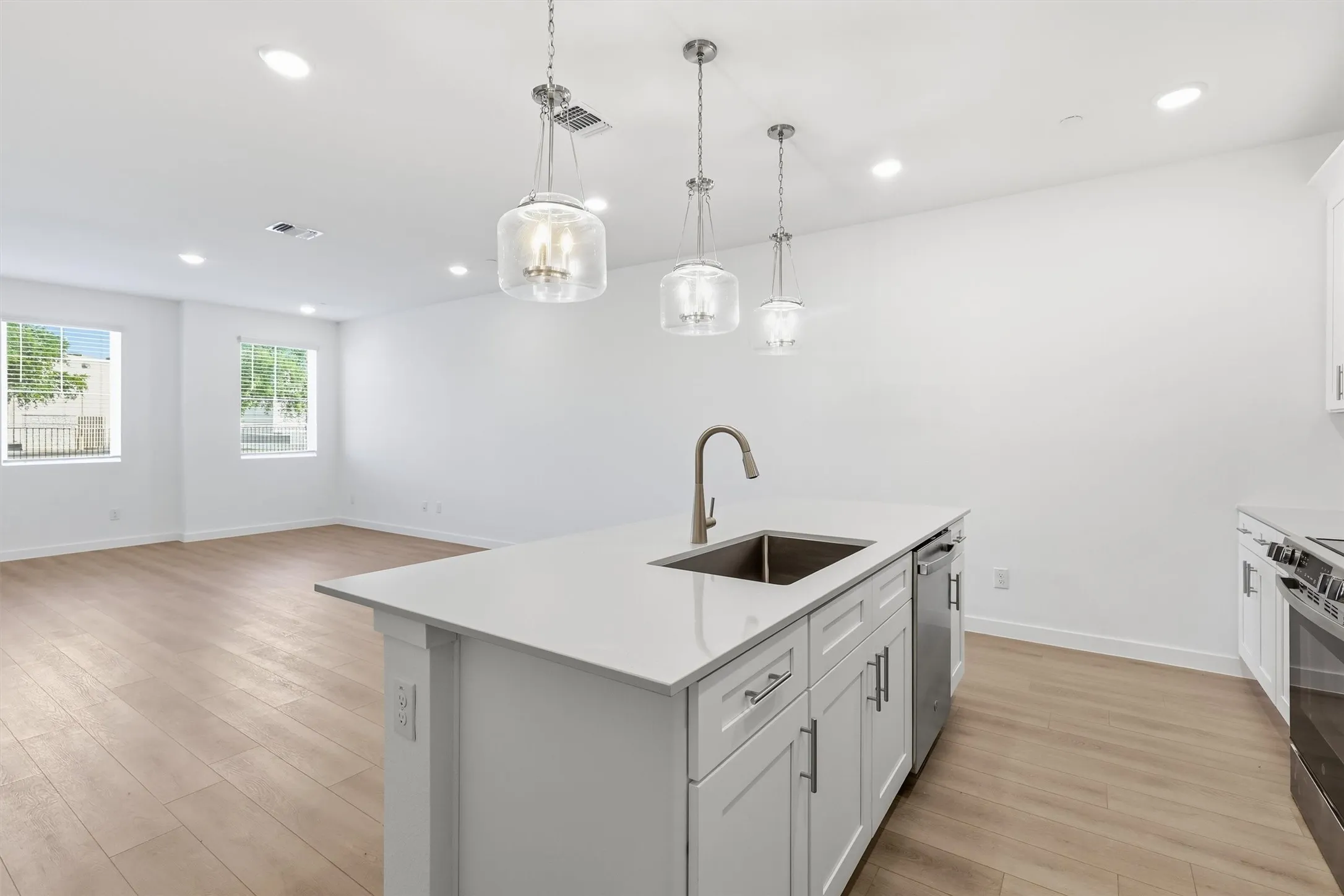 Kitchen island with an undermount sink, gooseneck faucet, and white shaker cabinetry